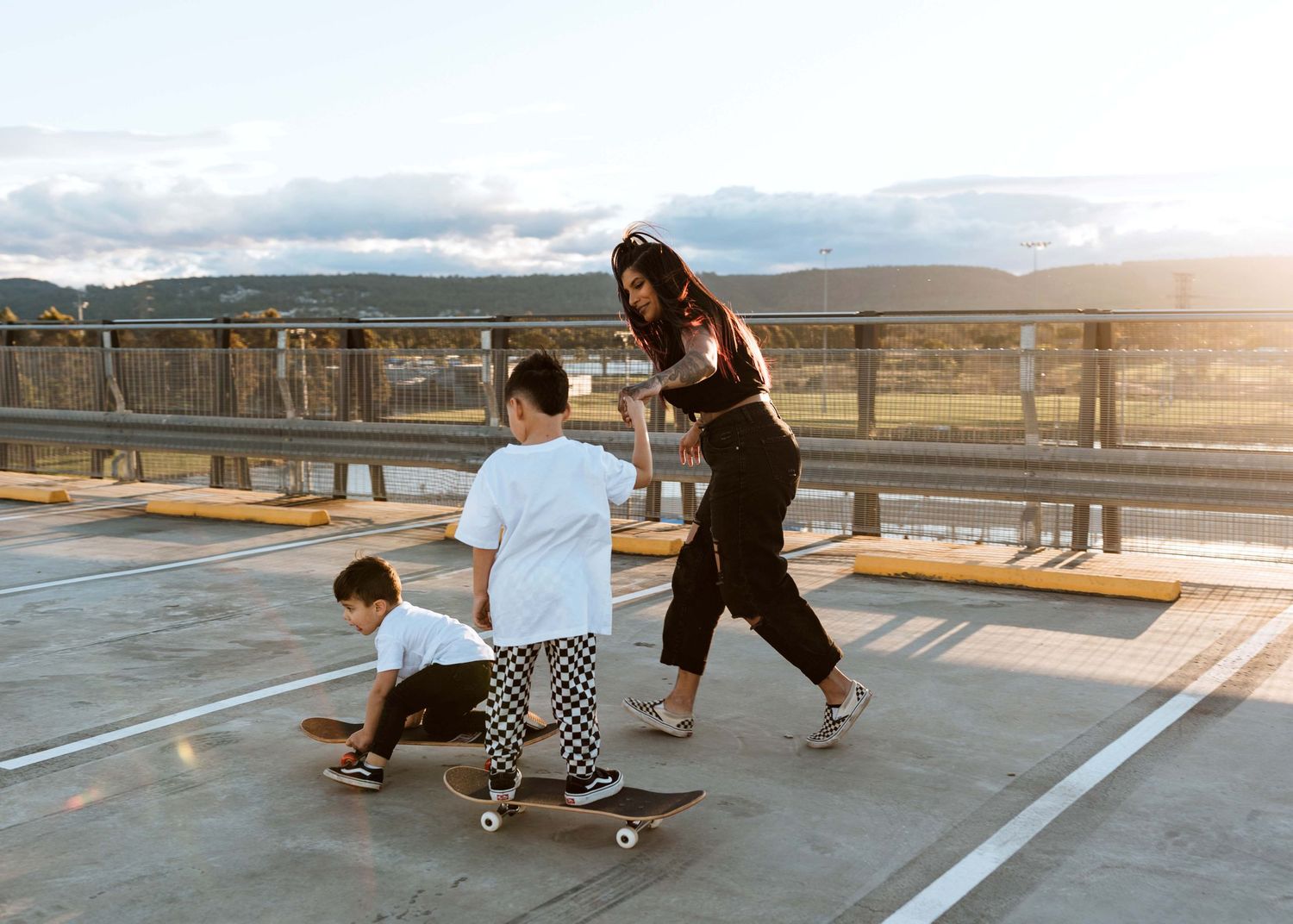 Family photoshoot skateboarding at sunset on a rooftop carpark in Penrith