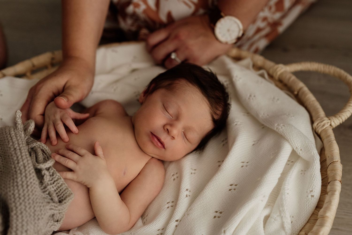 Newborn baby asleep in a Moses basket