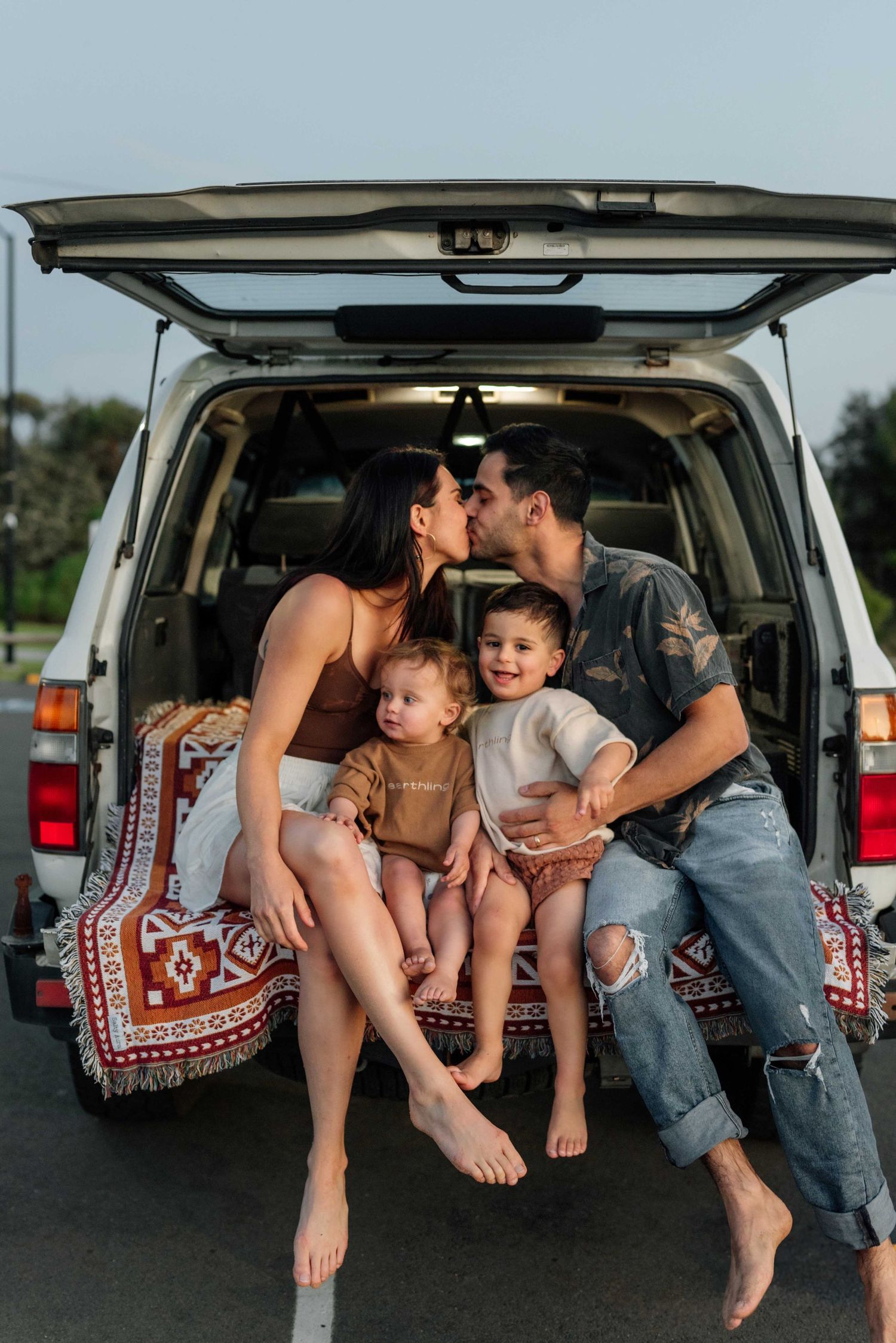 Beachy family sitting in the back of their 4WD after a beach photoshoot