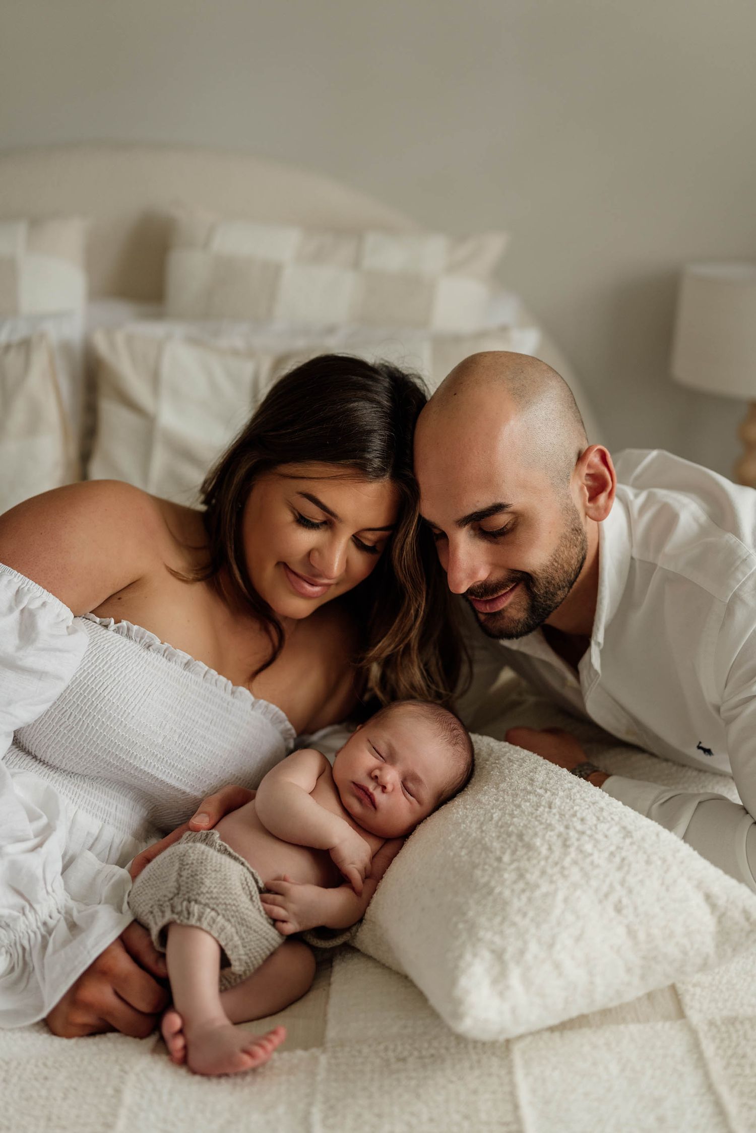 Mother and father looking down on sleeping newborn baby