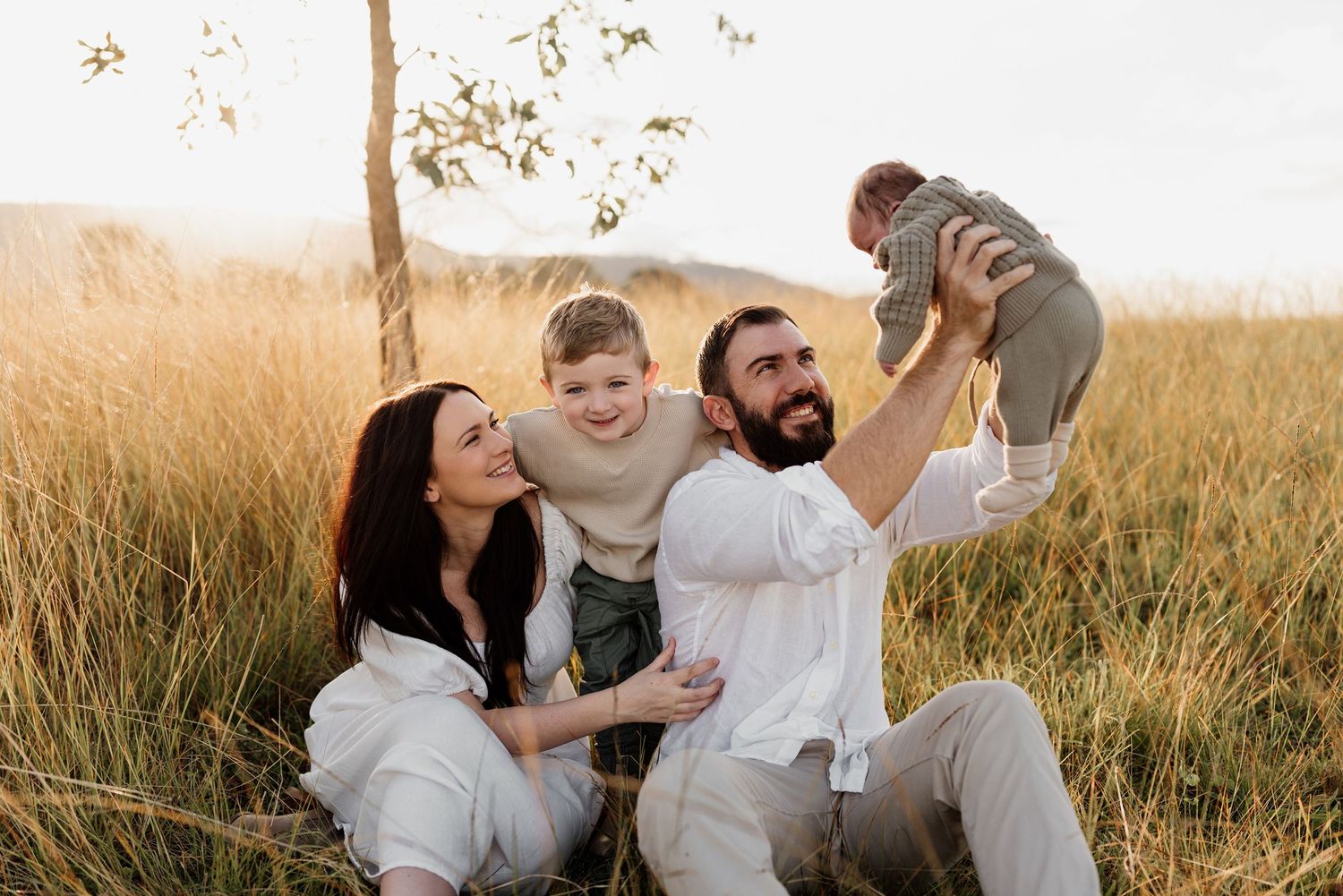 Family photoshoot in long grass and mother with long white dress