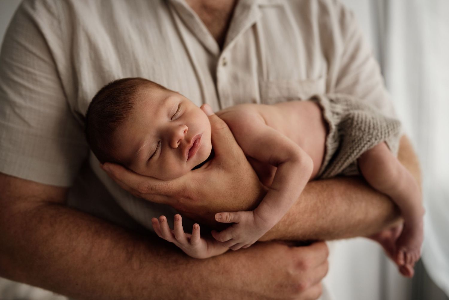 Father holding newborn baby in his arms