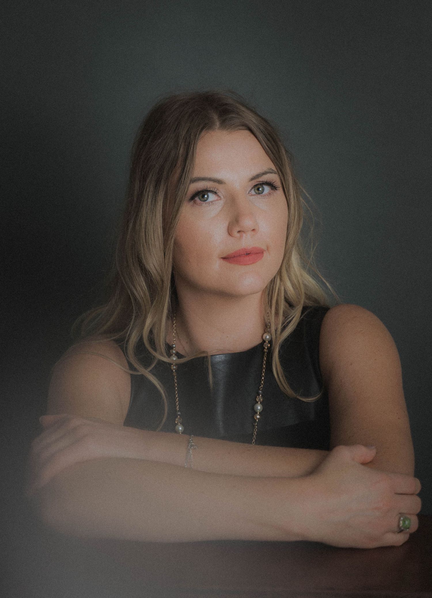 Artistic portrait series showing woman in dark setting with blonde hair and sleeveless top making contemplative poses.