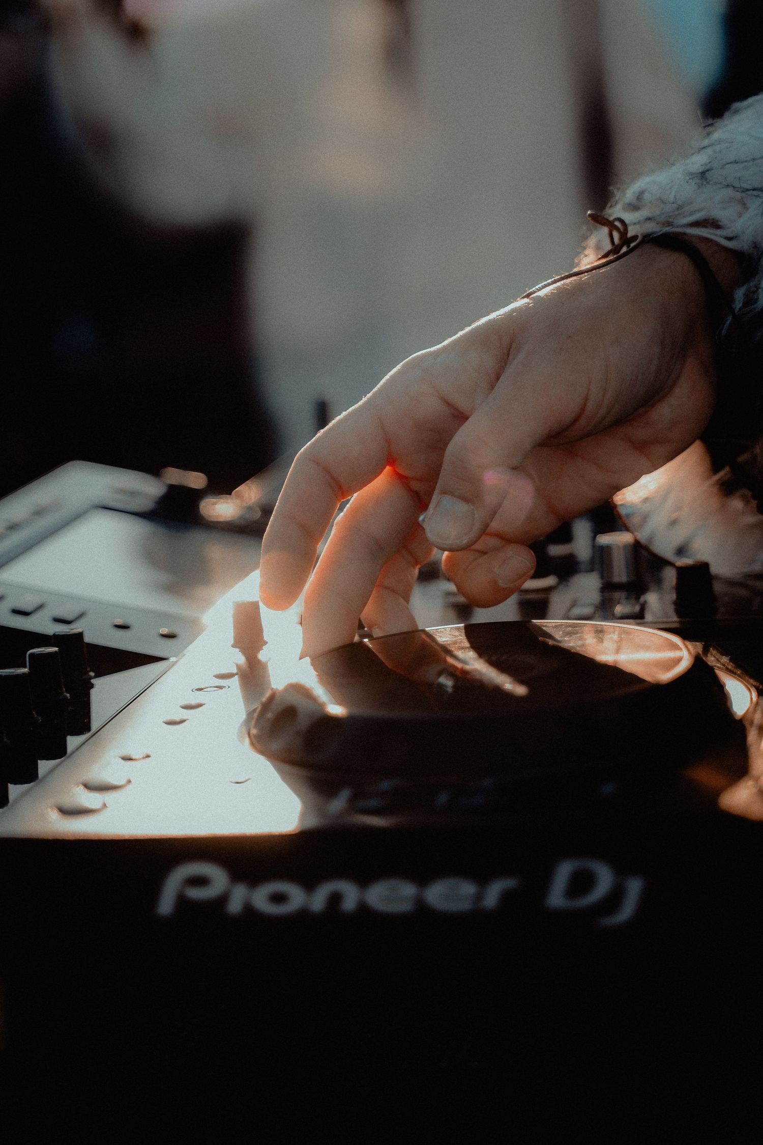 Close-up shots of hands operating Pioneer DJ equipment in dark lighting showing mixing console controls.