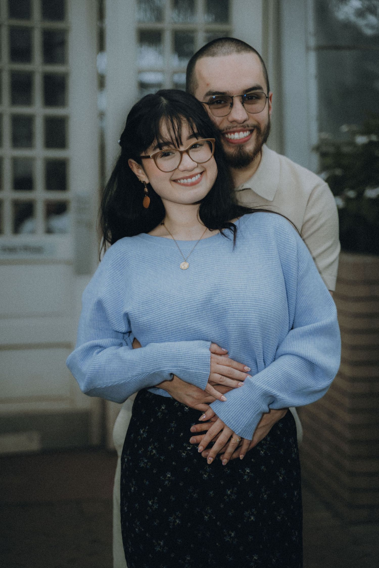 A couple shares a tender moment together in a series of three photos wearing blue and black outfits.