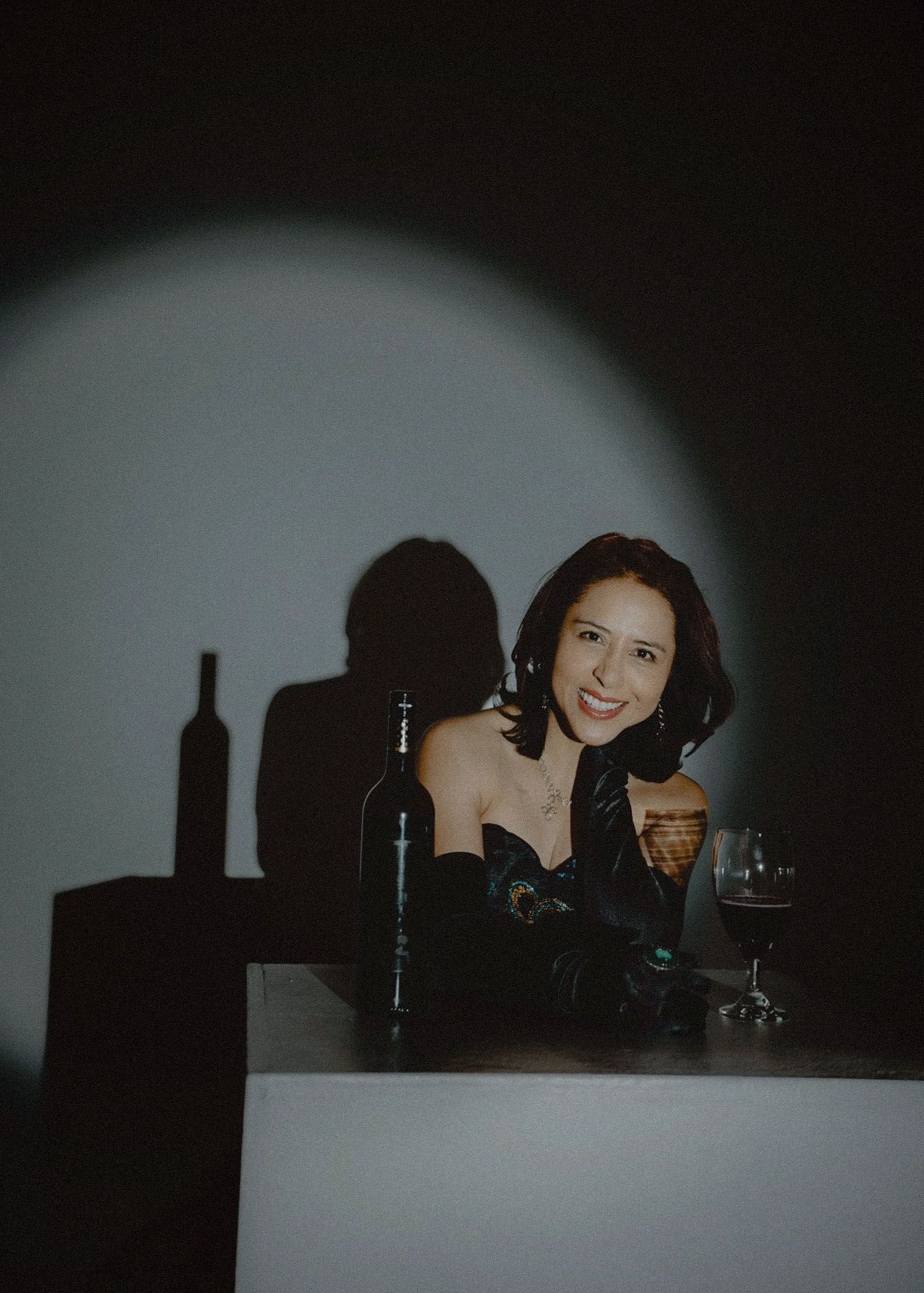 A city skyline silhouette creates a dark backdrop against a dimly lit scene with figures in the foreground.