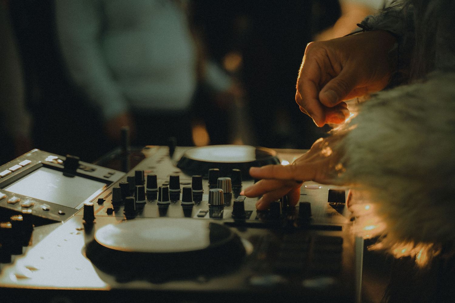 Close-up view of professional audio mixing equipment and control boards in low light setting.