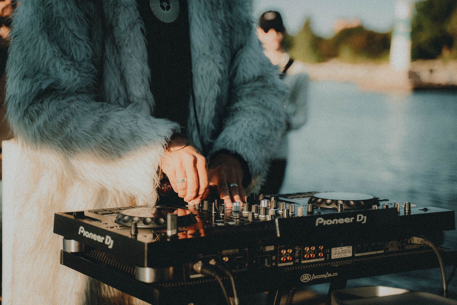 DJ equipment and mixers in a dark setting with ambient lighting creating a moody atmosphere.