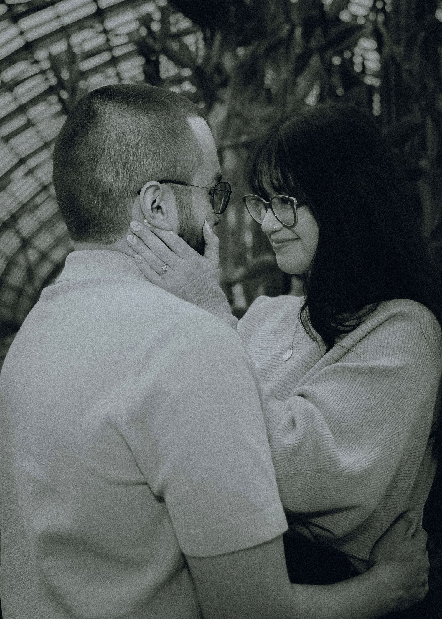 A black and white photo sequence shows two people in a romantic embrace and kiss against a greenhouse window background.