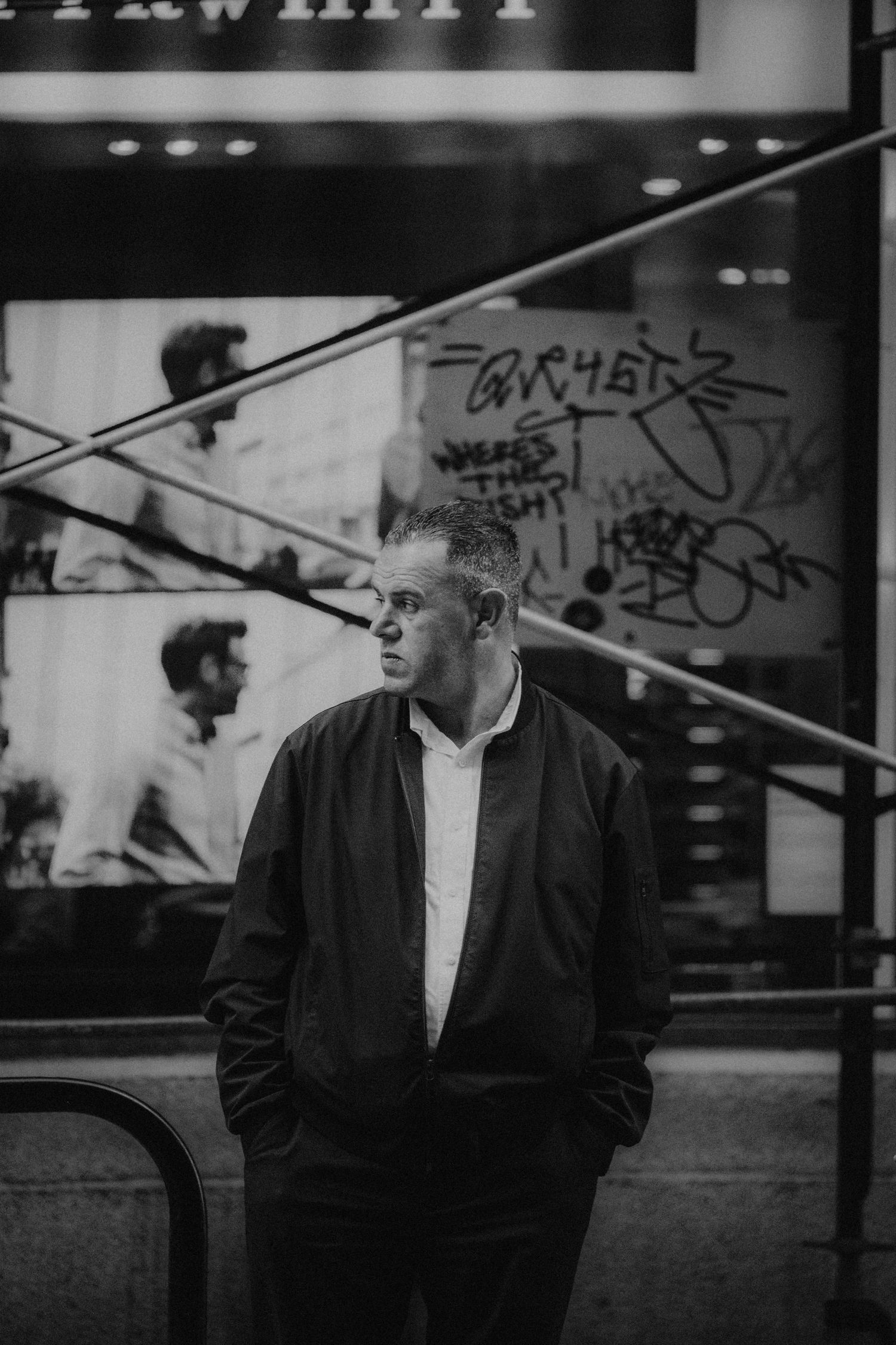 Moody black and white photo series showing a person in dark jacket against urban backdrop with dramatic lighting.