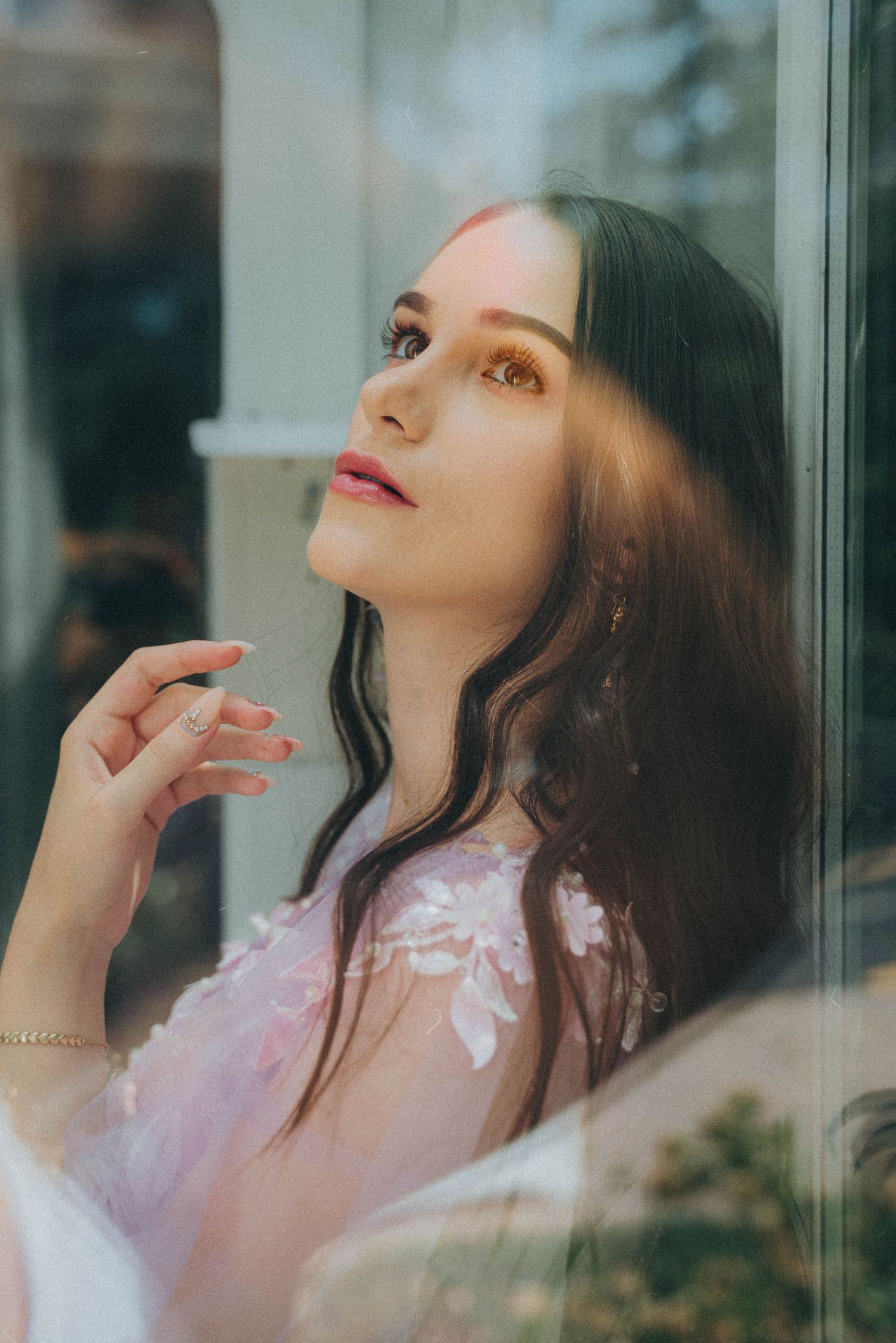 Dreamy indoor portraits featuring a delicate lavender dress with pink floral details against reflective windows.
