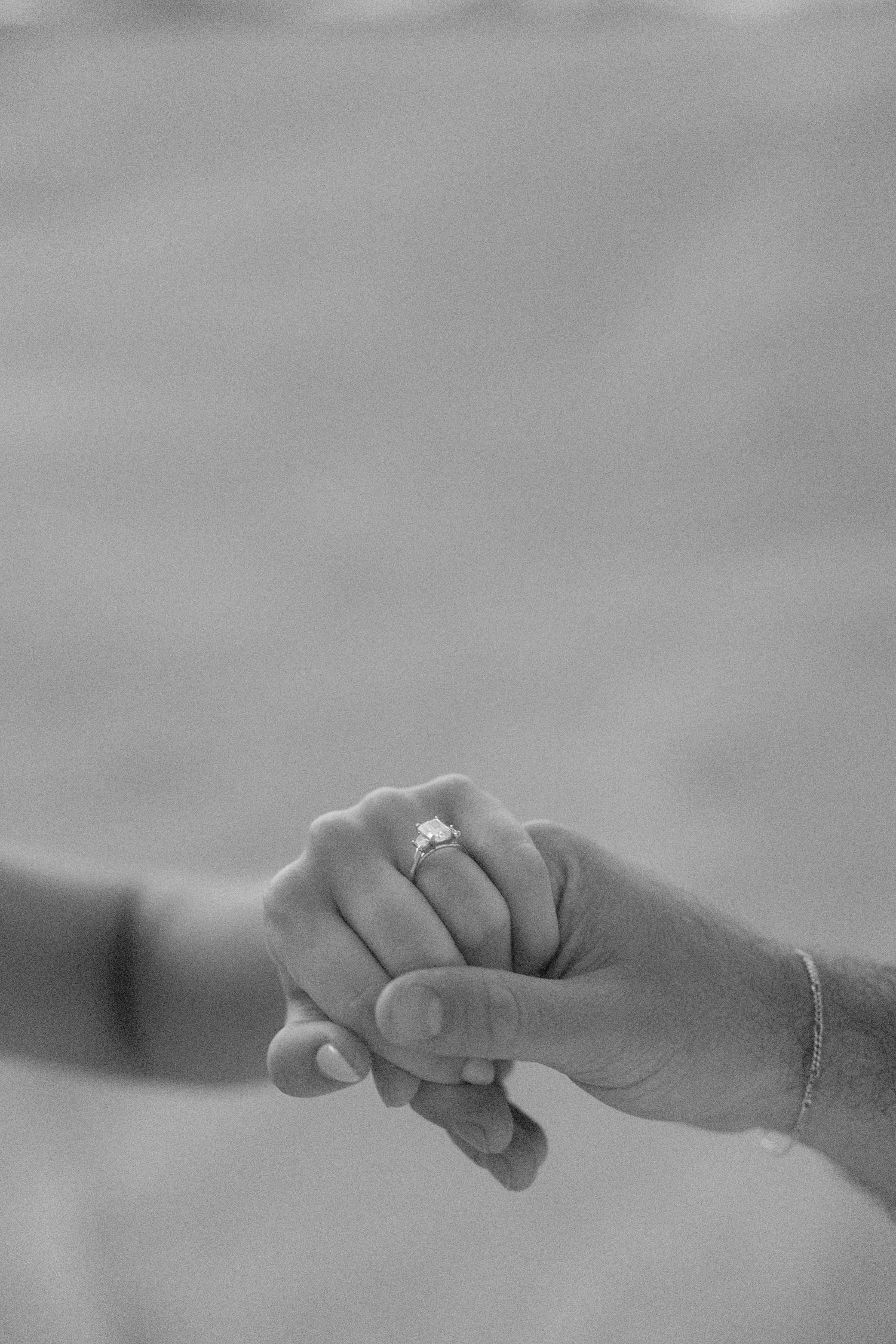A sequence of black and white photographs showing hands reaching and connecting with each other in a continuous line.
