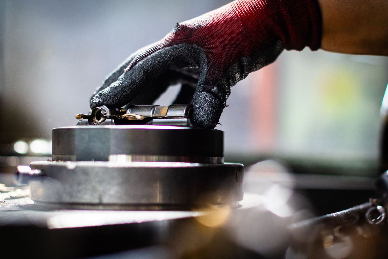 Close-up of a hand holding the metal tooling to finish valves in a industrial valve production factory.