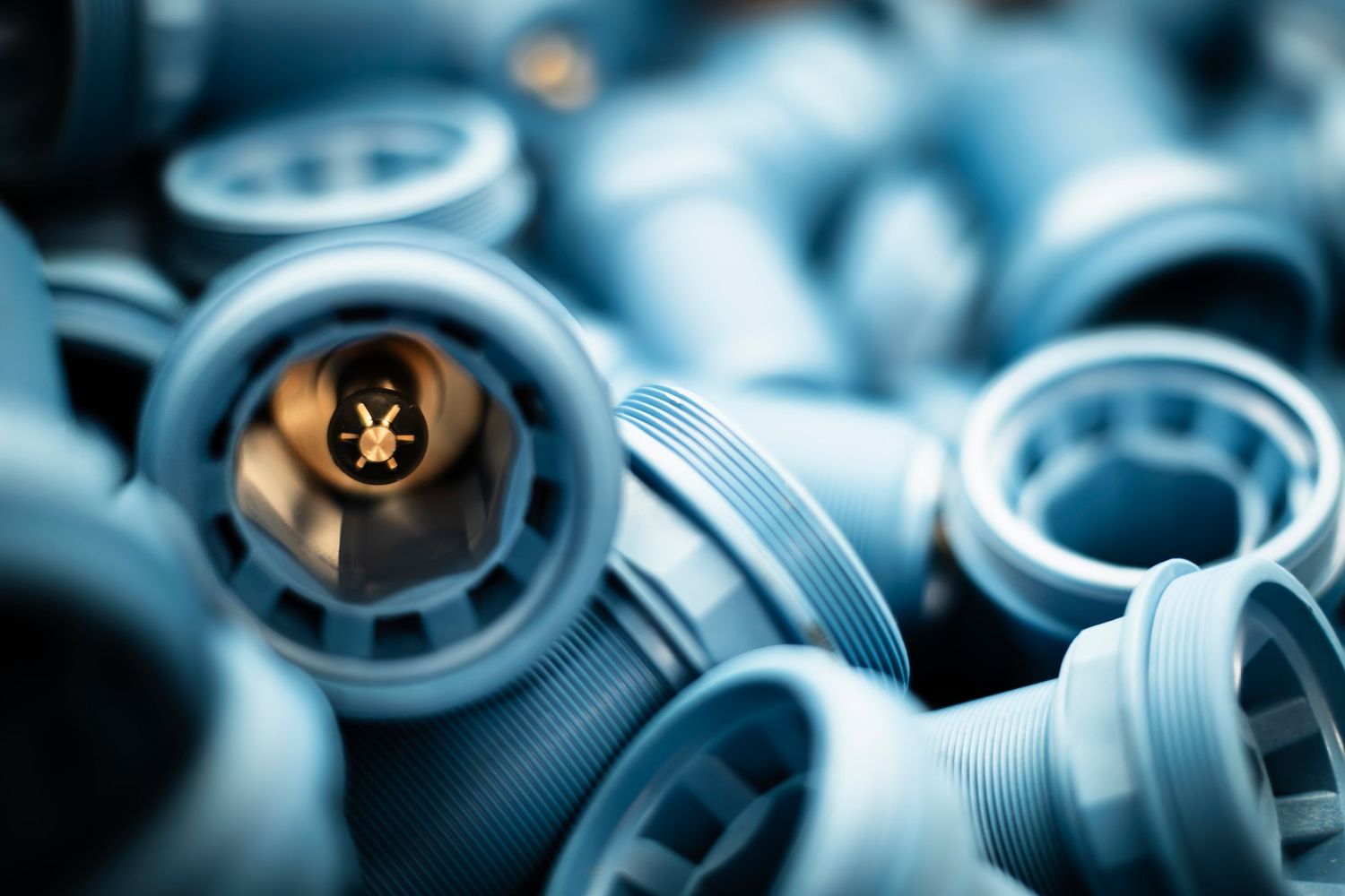 Close-up shot of blue HDPE pipe fittings with one fitting showing the internal pipe fittings in a glowing light.
