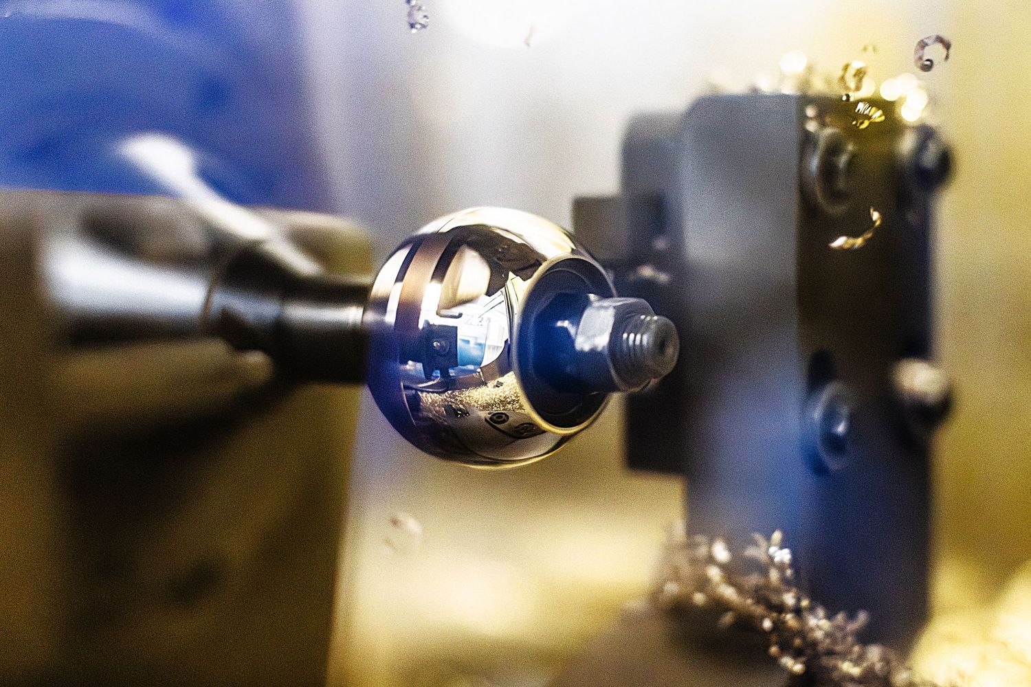 Close-up macro photography showing the precise machining of brass valve components with an industrial lathe.