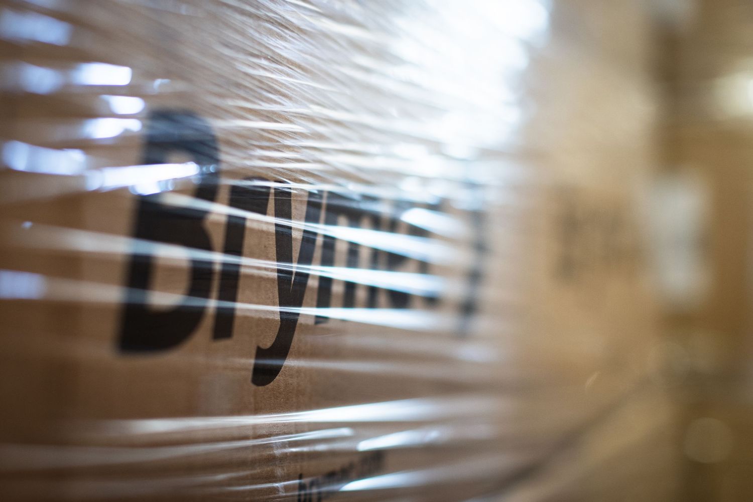 Amazon branded cardboard boxes wrapped in clear plastic stretch wrap for shipping and storage.