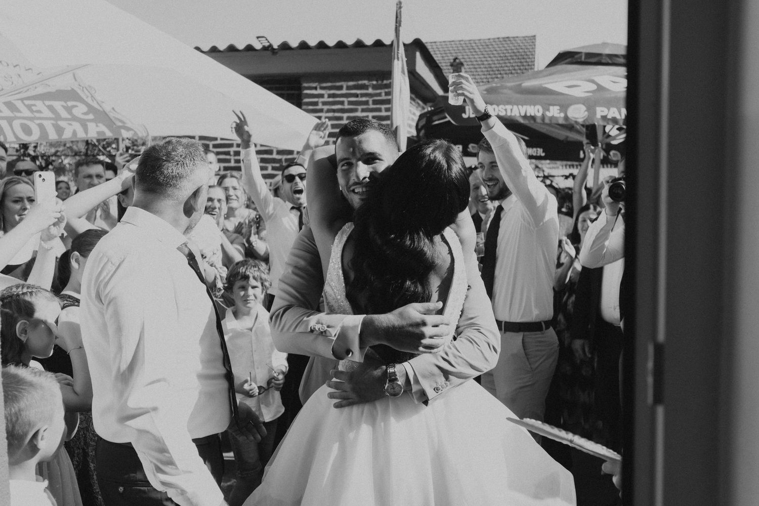 Black and white wedding celebration photo showing joyful dancing and expressions.