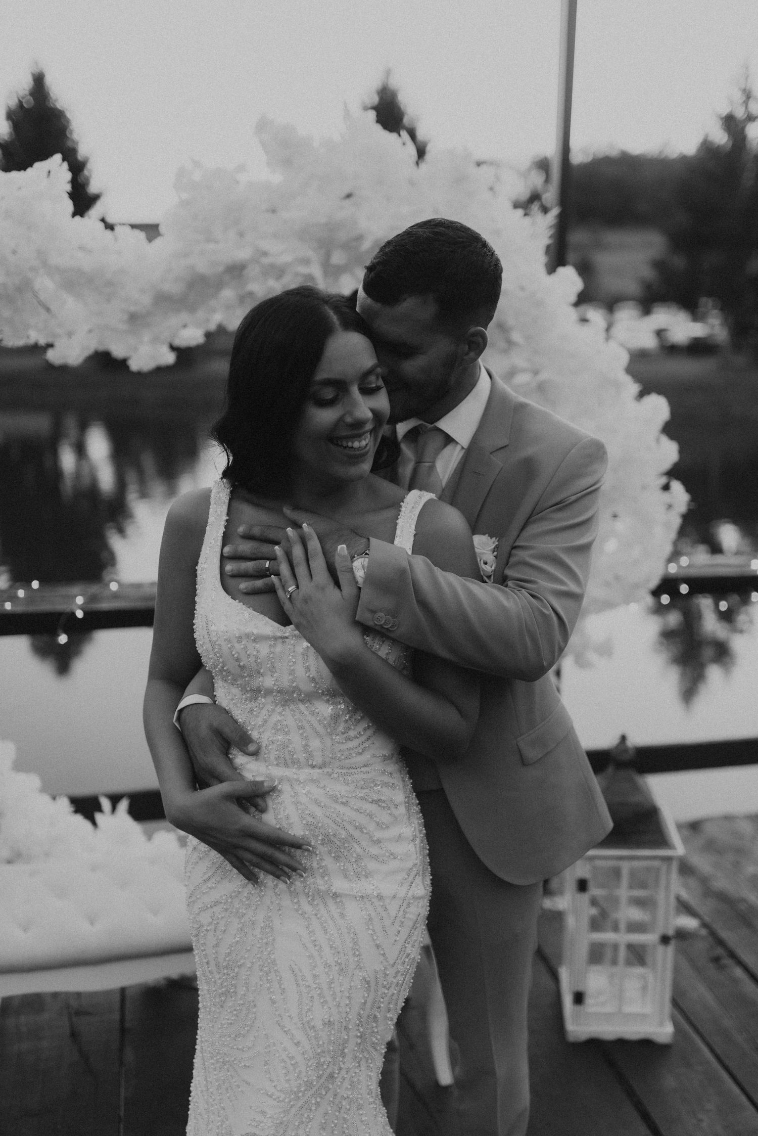 A black and white portrait of a happy couple embracing with smoke effects in the background.