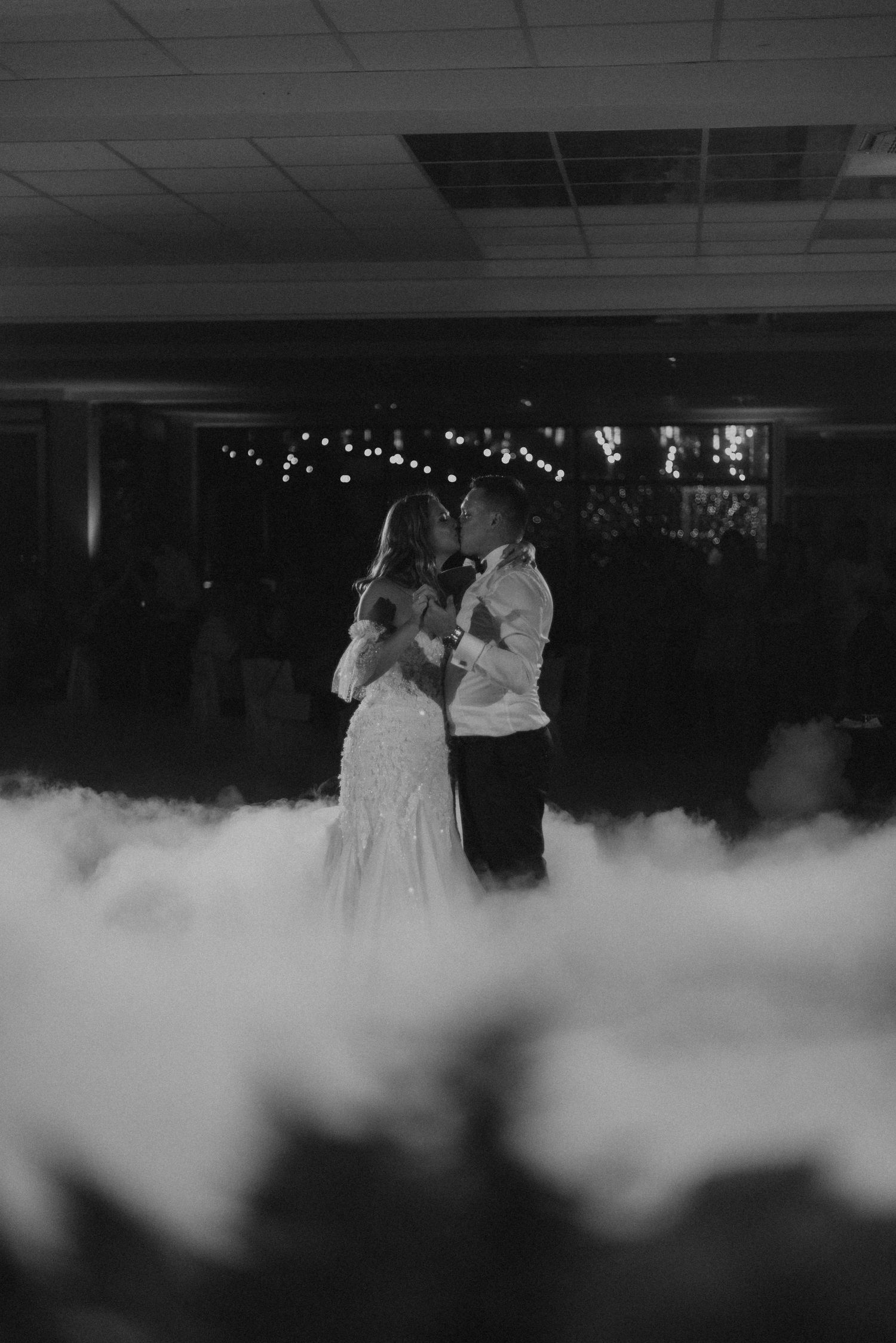 A couple dancing surrounded by fog on their wedding dance floor.