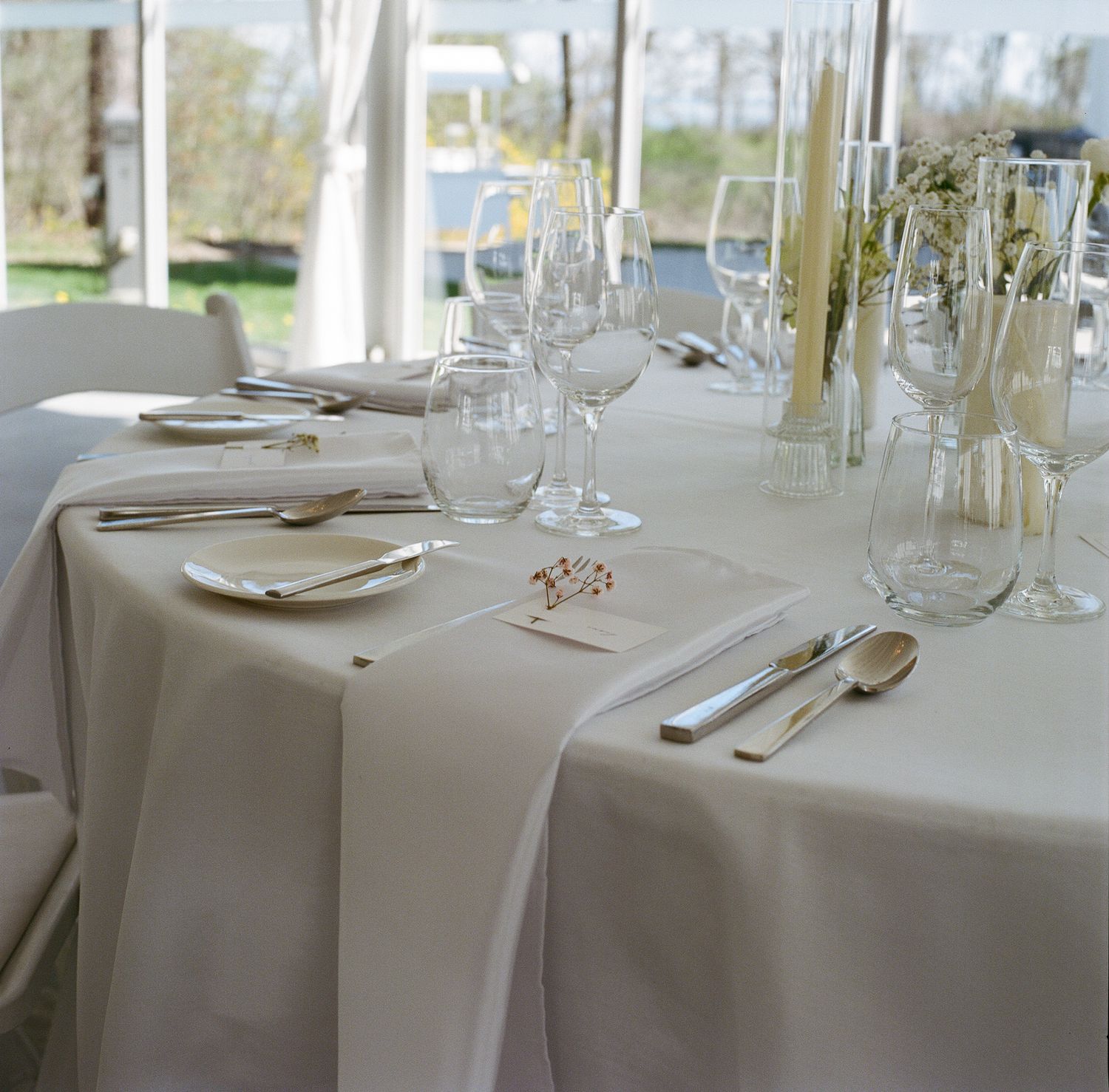 An elegant table setting with crisp white linens, polished silverware and wine glasses for a formal dining event.