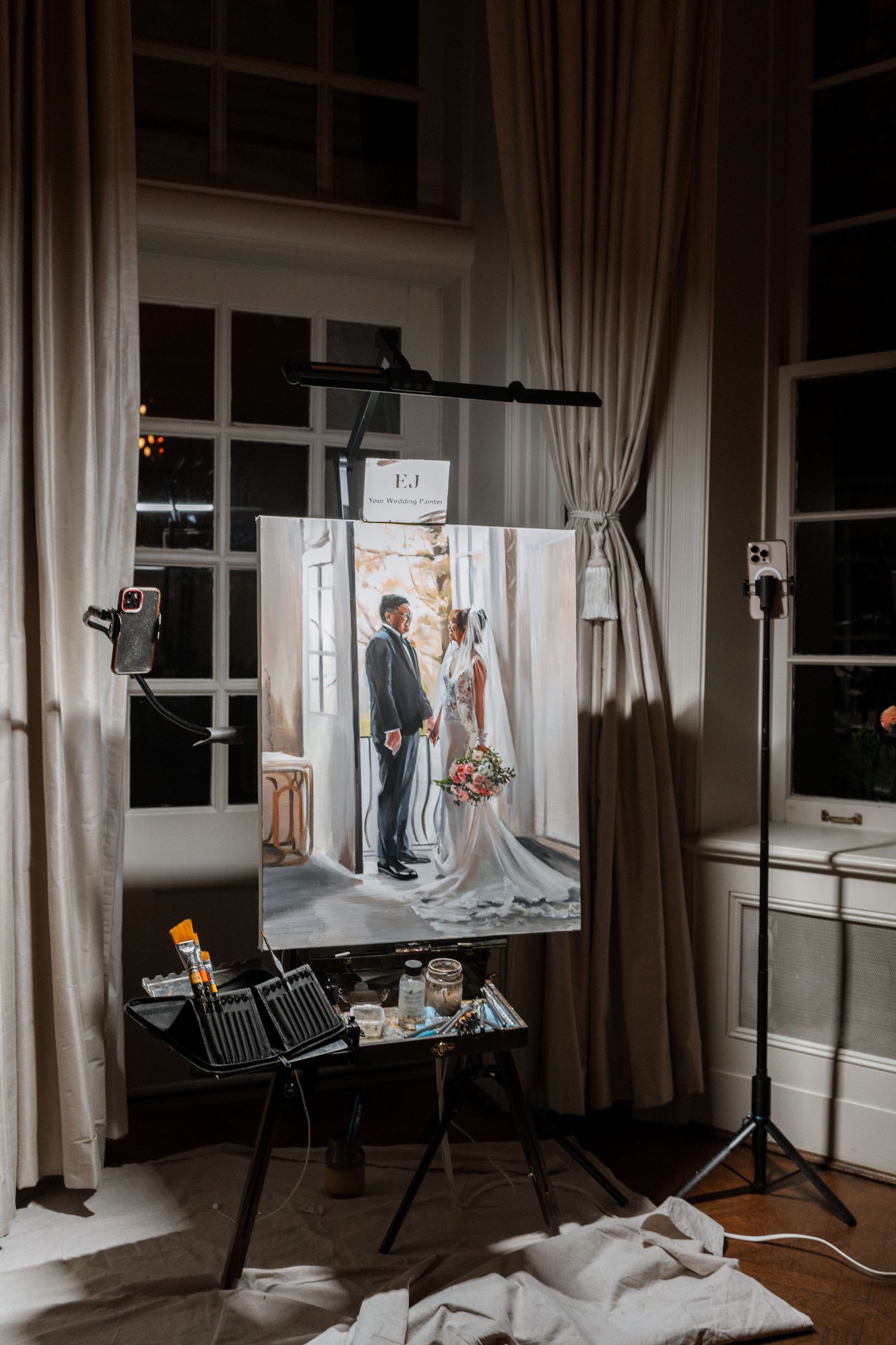 A professional photography setup with a wedding photo on display, studio lighting and curtains in an indoor setting.