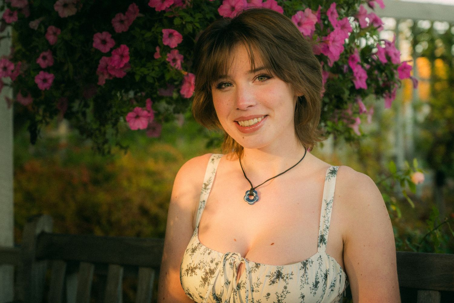 A summer portrait with pink flowers and natural lighting in the background.