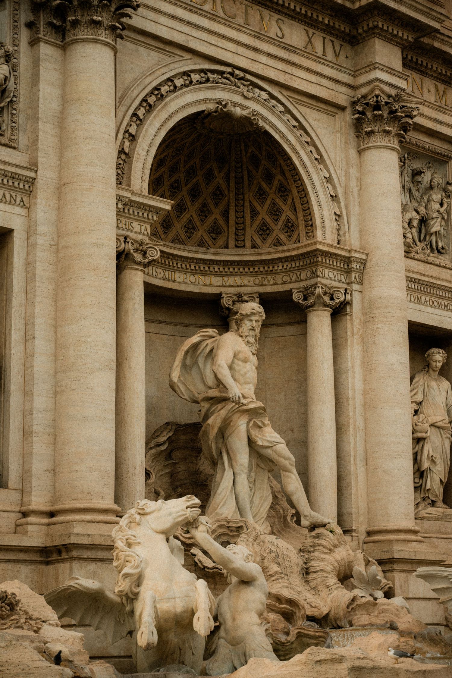 Historic Trevi Fountain sculptures and architectural details in sepia tones.