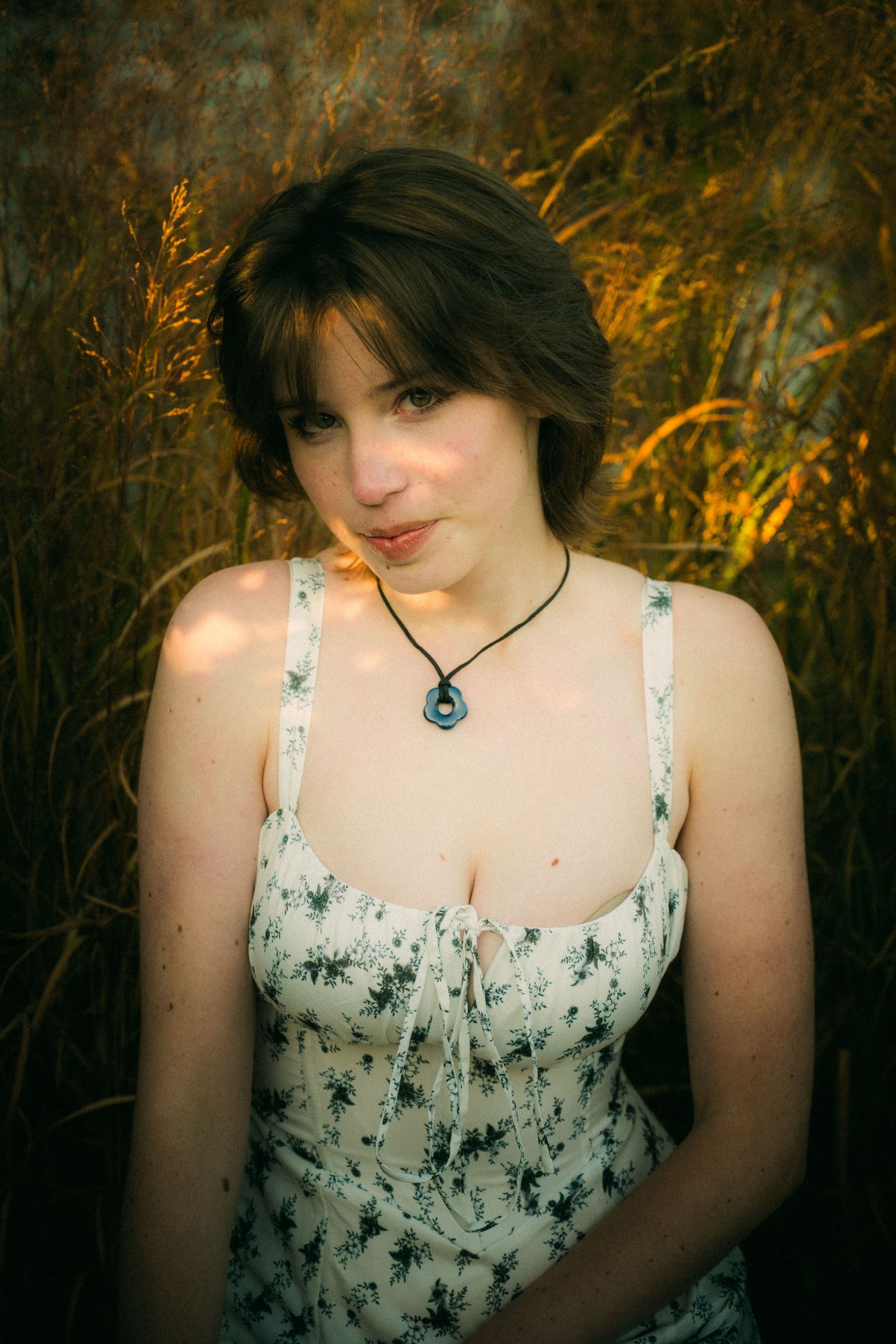 An outdoor portrait session with a white sundress against a natural autumn backdrop.
