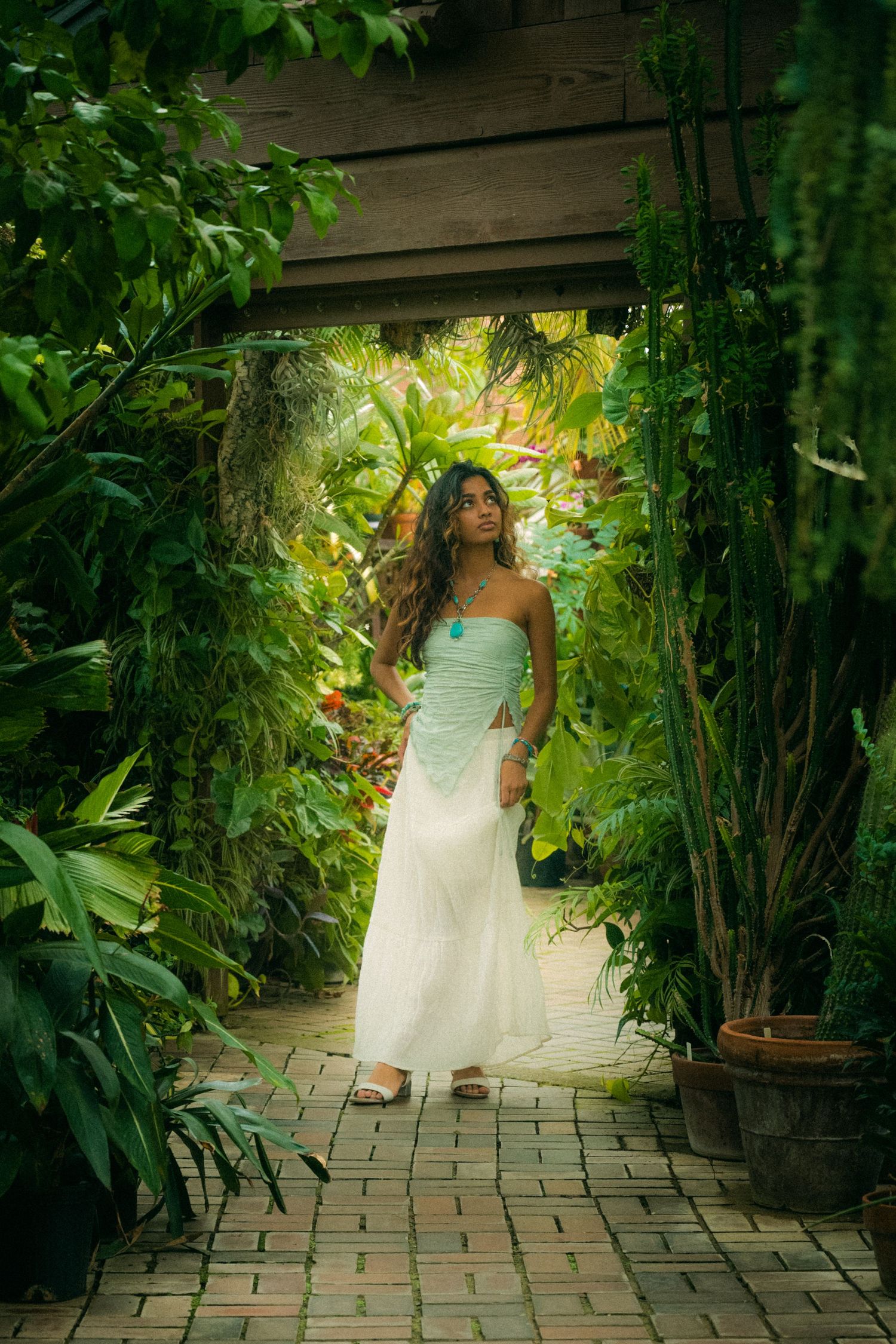A garden pathway scene with lush greenery and natural lighting creating a magical atmosphere.