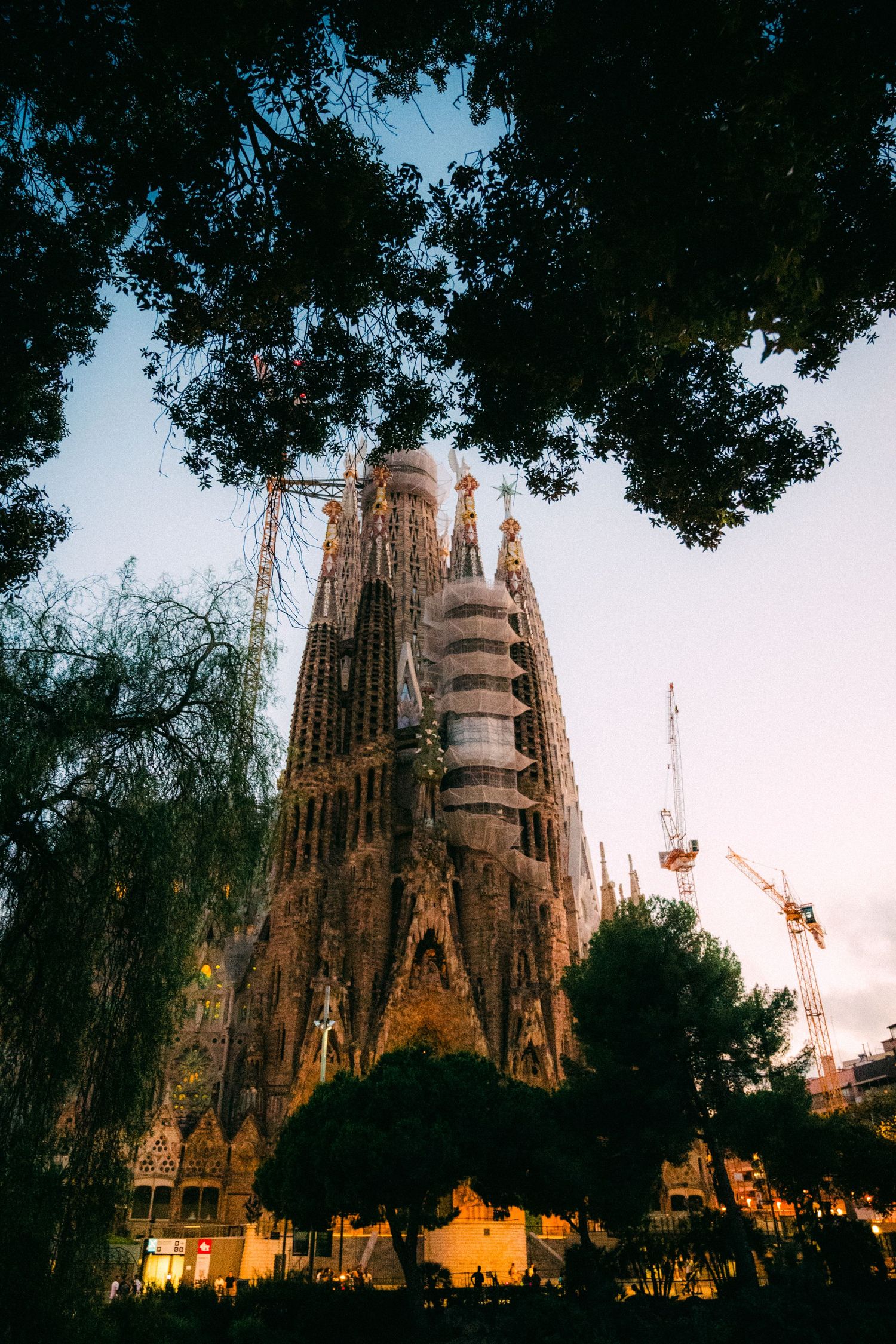 La Sagrada Familia's iconic spires silhouetted against twilight sky in Barcelona.