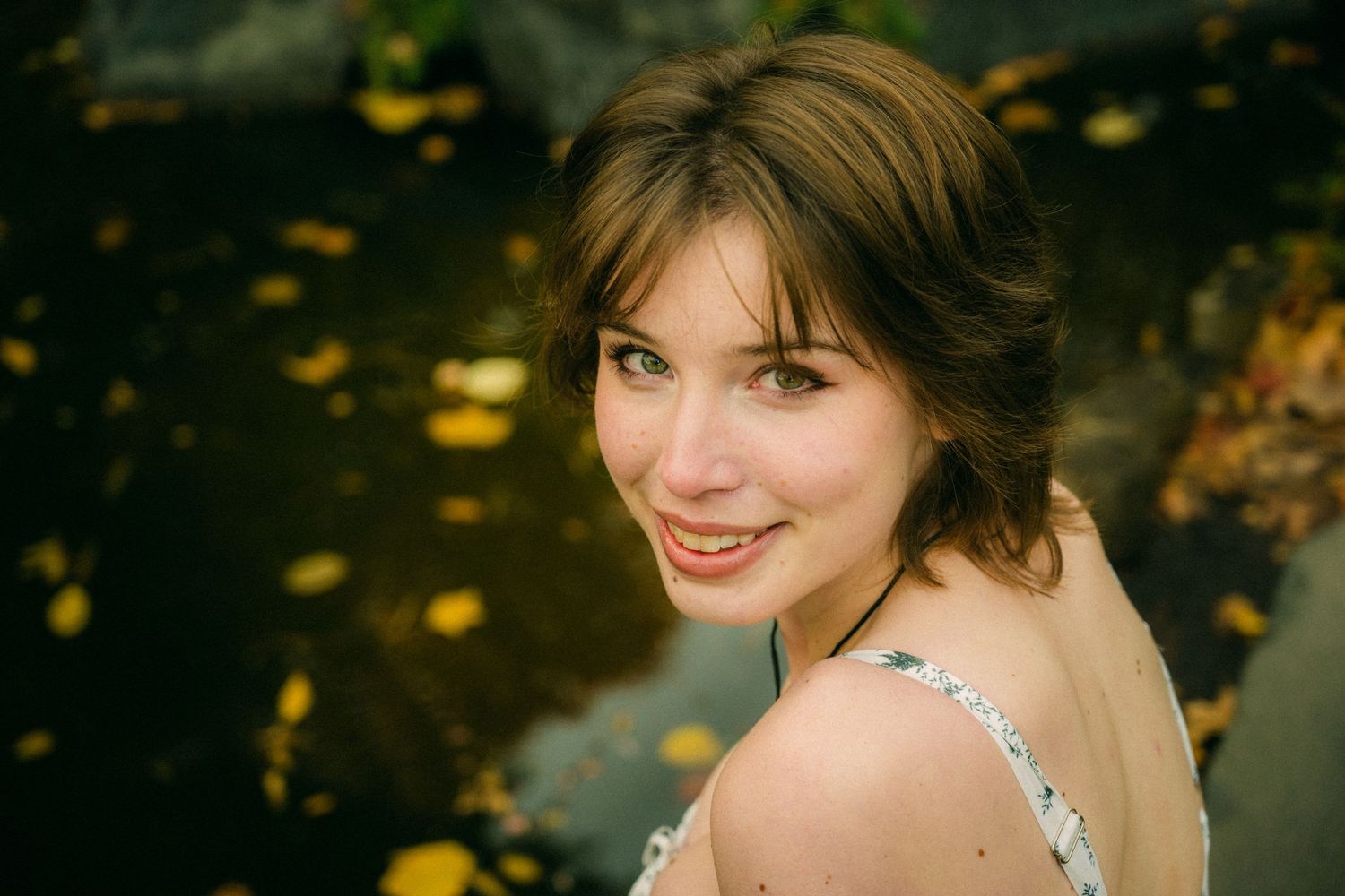 An artistic autumn portrait series featuring a white patterned dress in warm lighting.