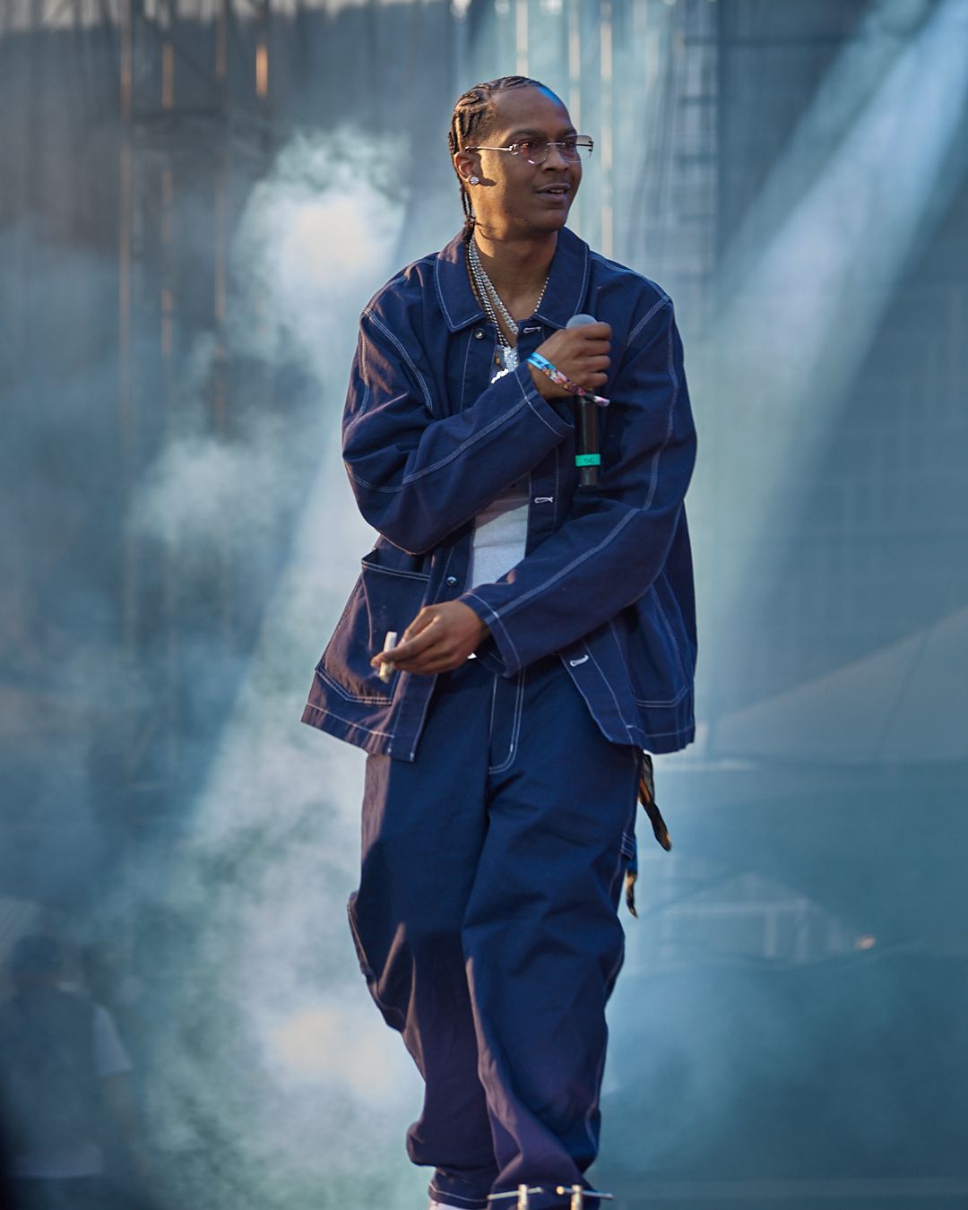 Performer in blue denim outfit dances through atmospheric stage fog. concrete boys