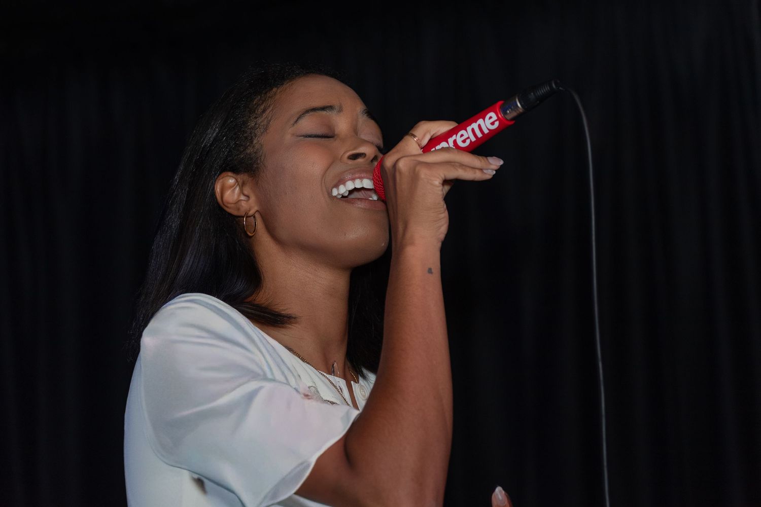 Energetic vocalist delivers emotional performance on dimly lit stage.