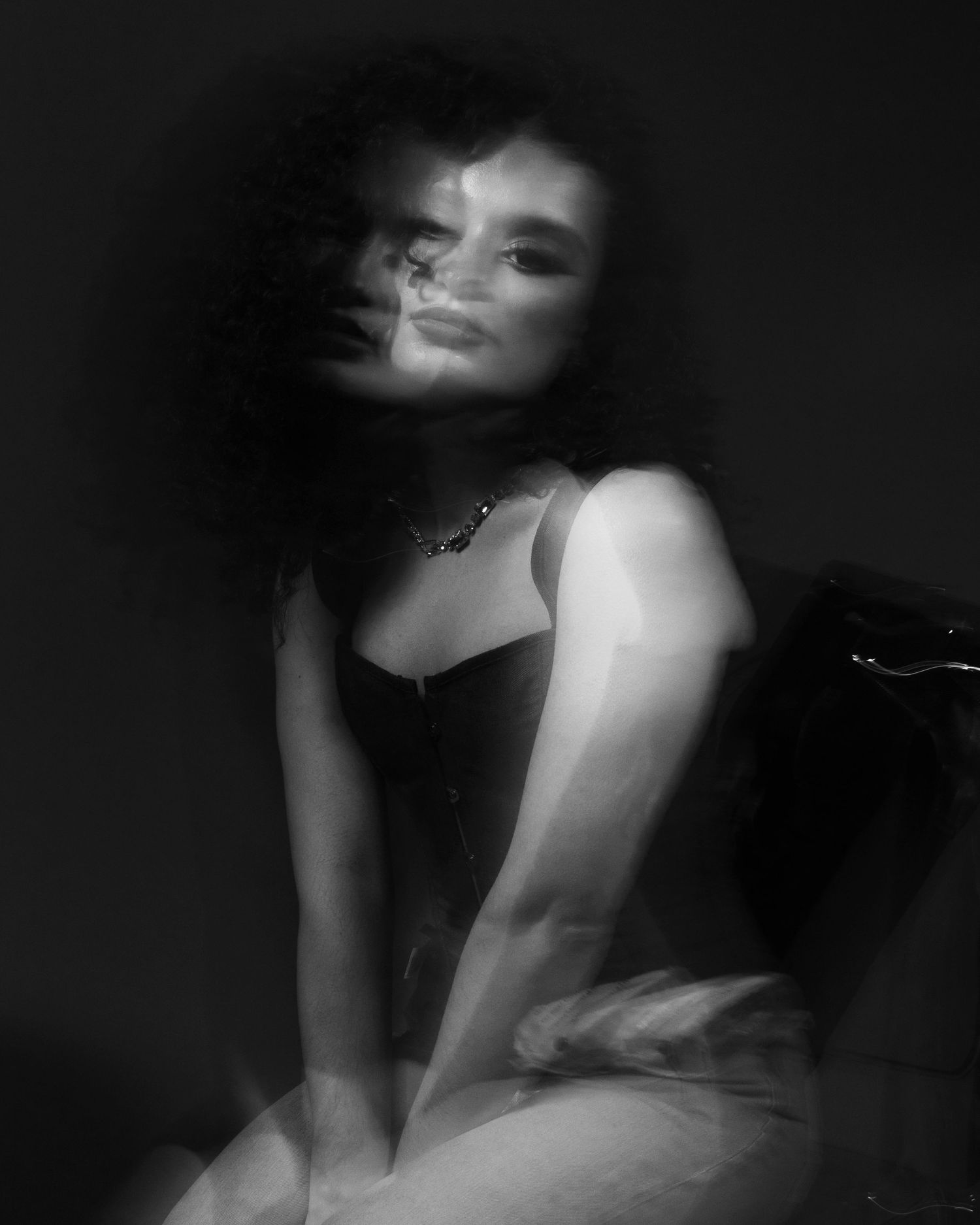 Artistic black and white portrait with dramatic lighting and movement effects.