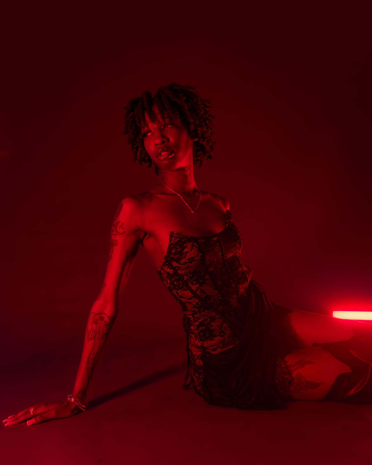 Silhouette in dramatic red lighting creating moody artistic composition.