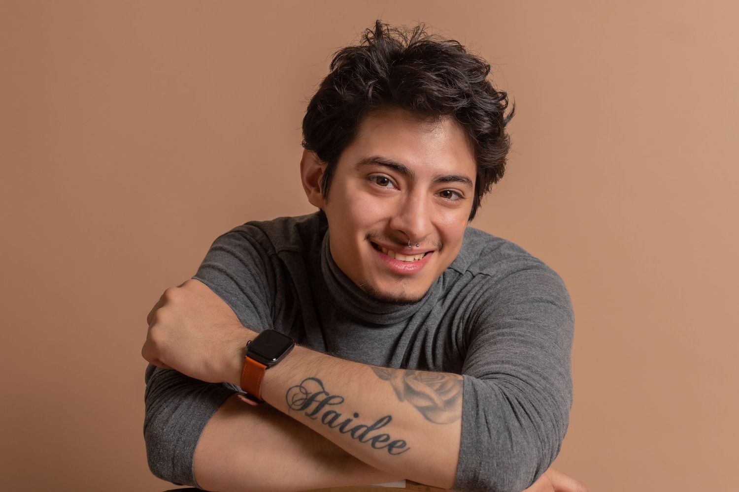 Studio portraits featuring casual gray sweater and relaxed poses.
