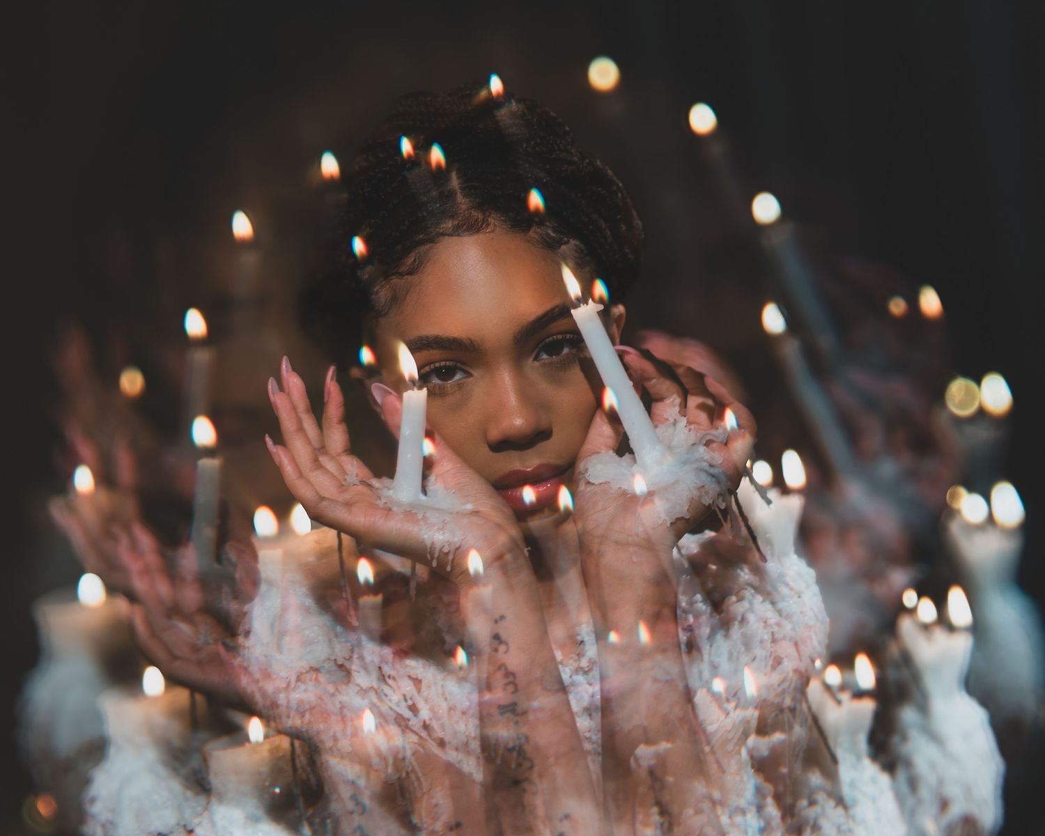 Multiple exposure shot with candles and bokeh lights creating ethereal effect. with candle wax clothing