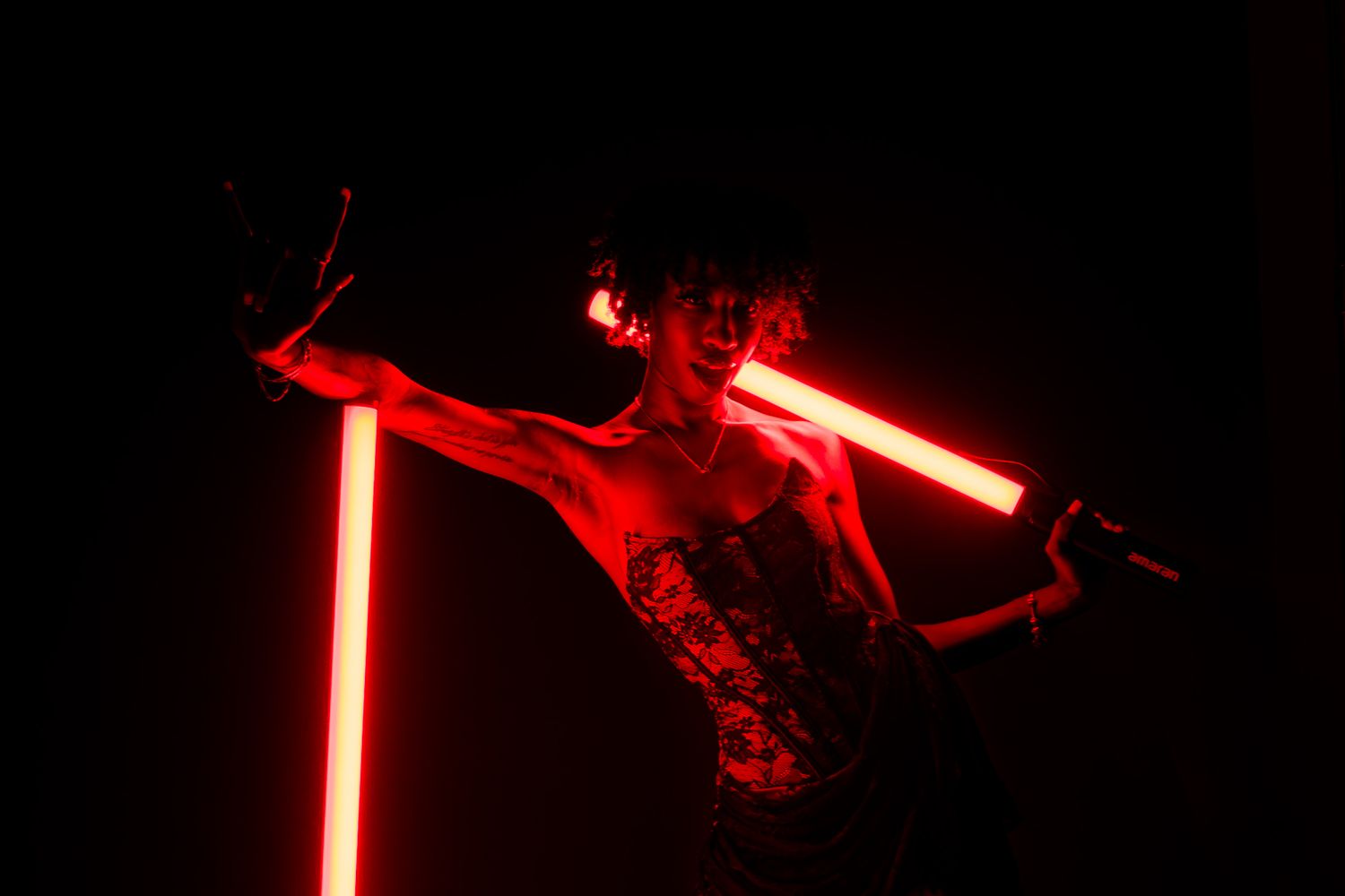 Red neon lights create dramatic shadows and silhouettes in a dark setting.