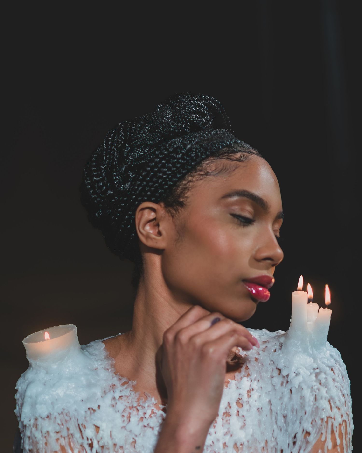 Elegant portrait with wax clothing and candlelight creating romantic ambiance.