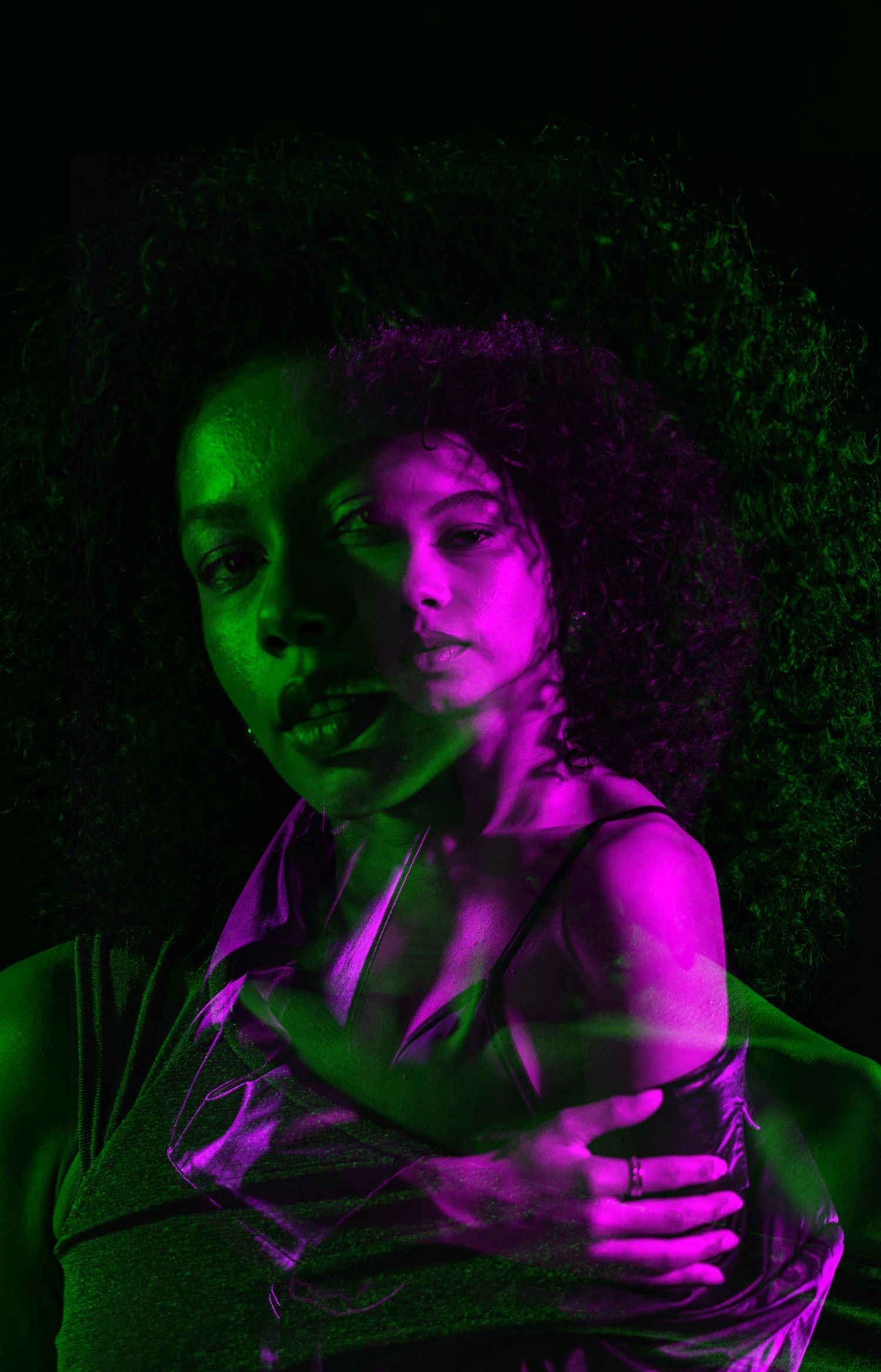 Dramatic portrait with neon purple and green lighting effects.