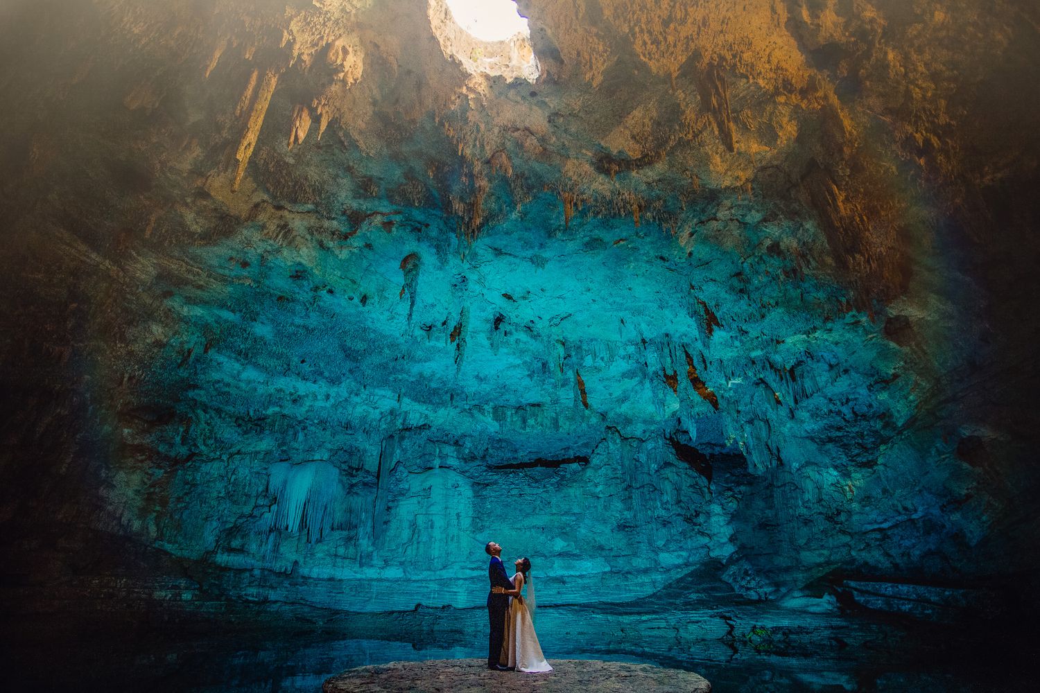 Dramatic series of cave photos transitions from dark orange to turquoise blue ending with a lighthouse silhouette.