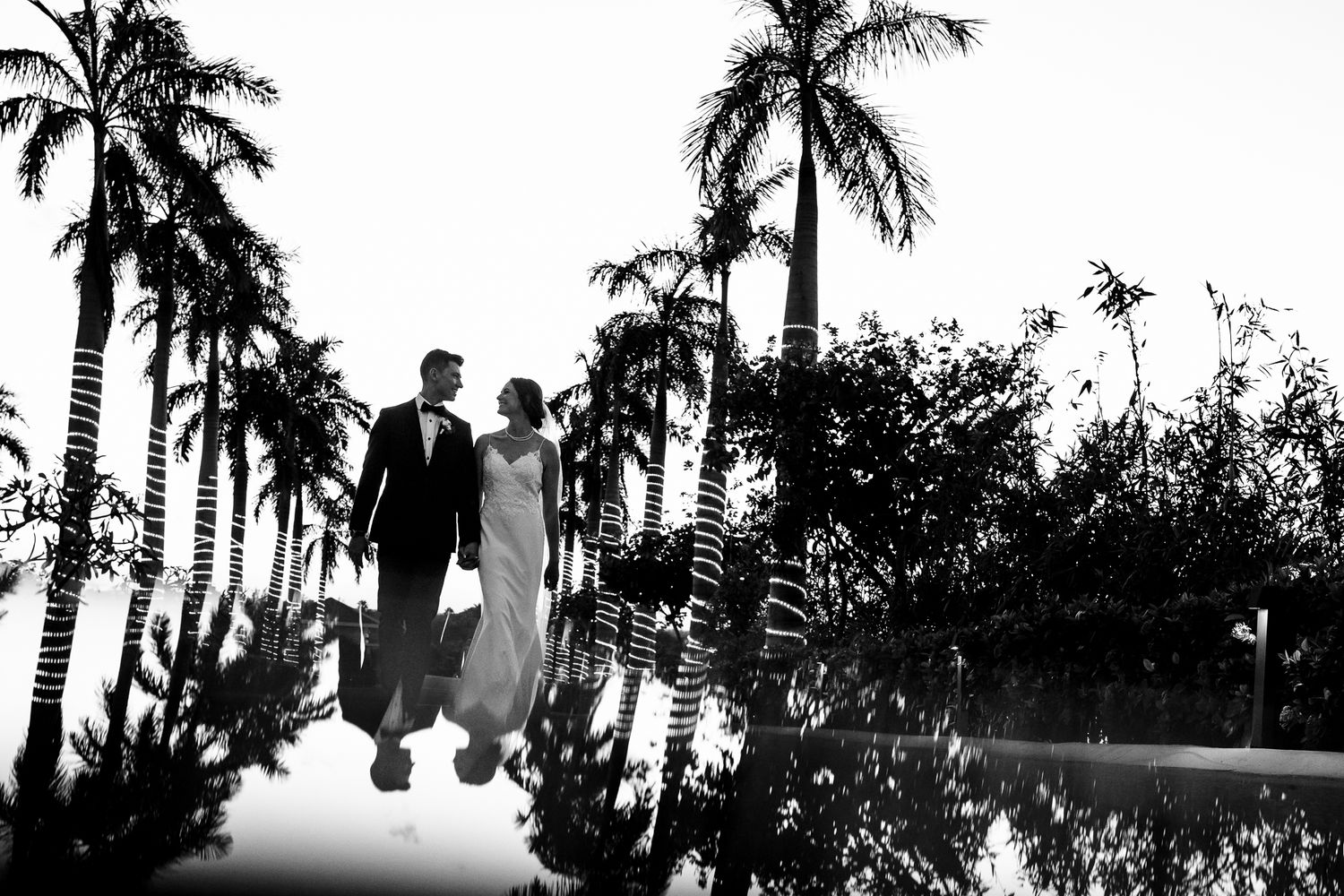 Bride and groom walk hand-in-hand among tropical palm trees Cancun Wedding Photographer, Destination Wedding Cancun,