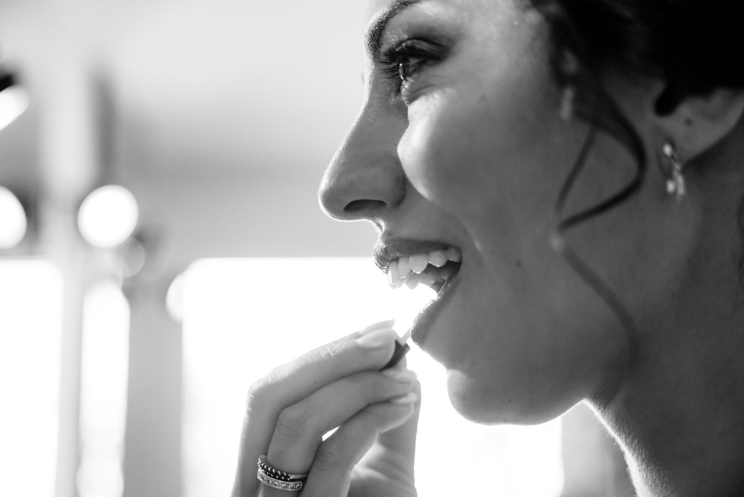 Bride laughing joyfully in black and white close-up portrait.
