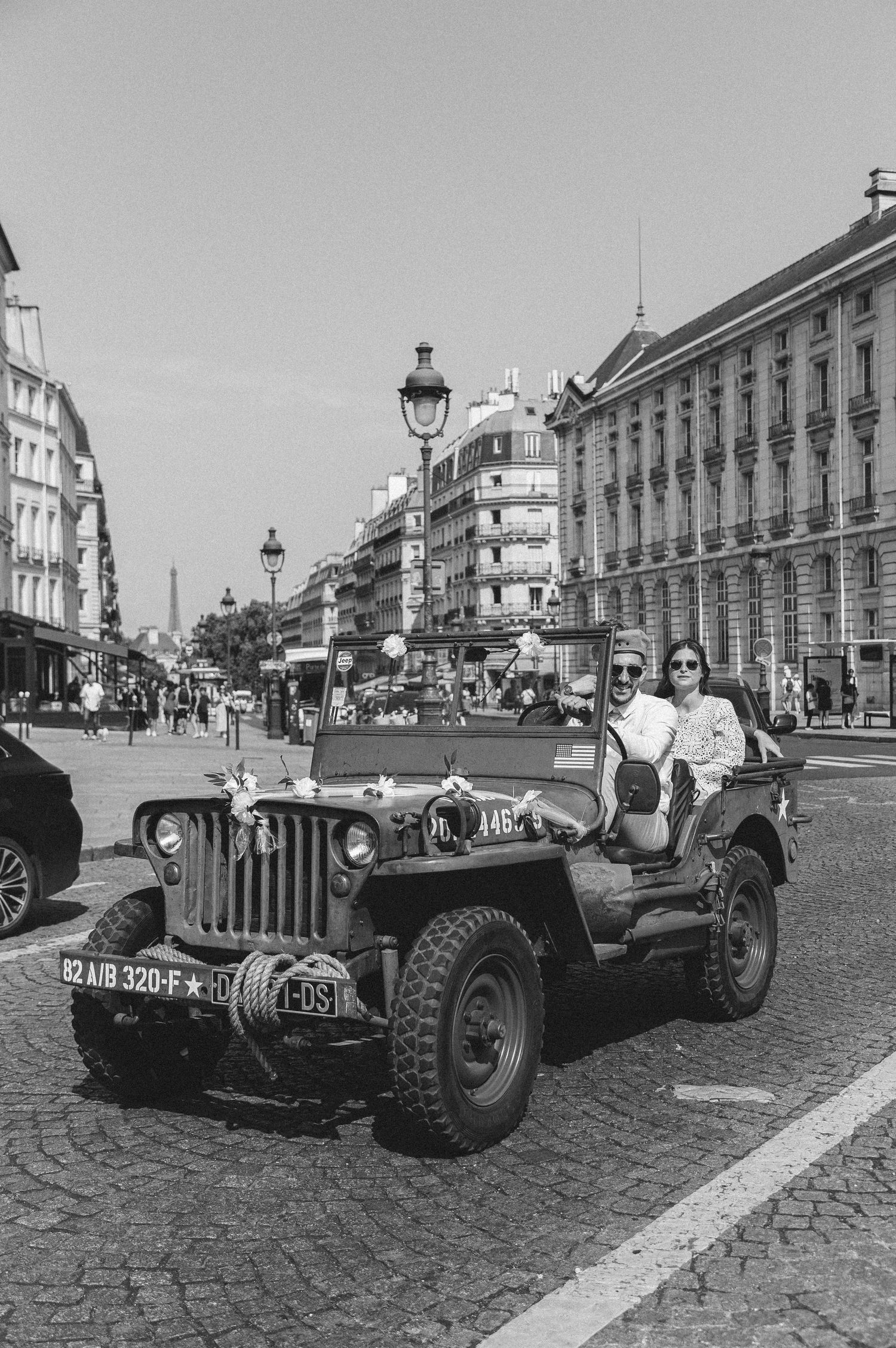 Vintage black and white photographs showing classic cars displayed on a cobblestone street.