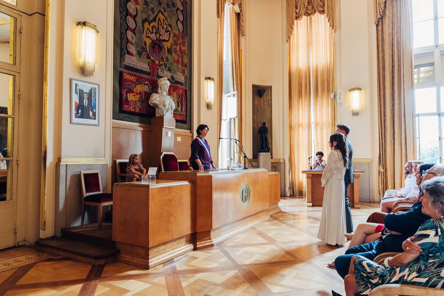 Elegant hotel lobby interior with high ceilings, ornate decor and reception desk illuminated by warm lighting.