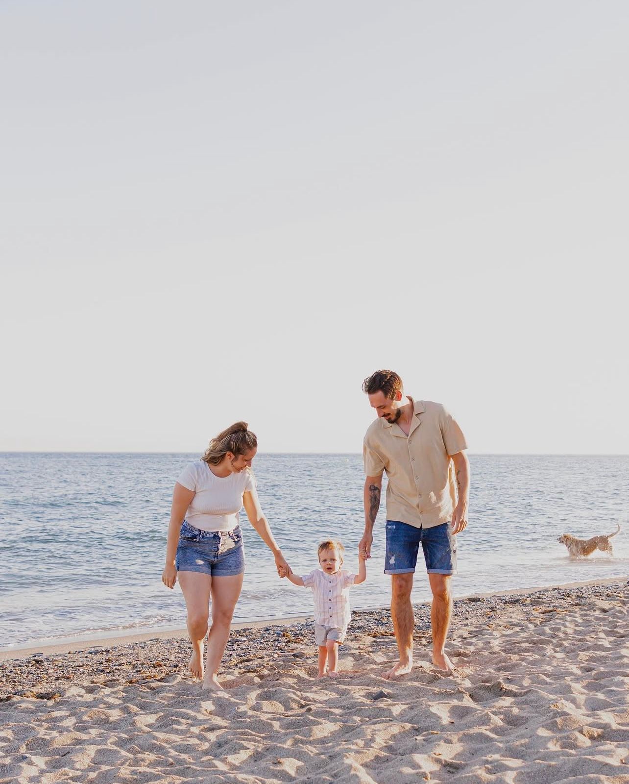 Candid family moments captured during a beach photoshoot at golden hour.