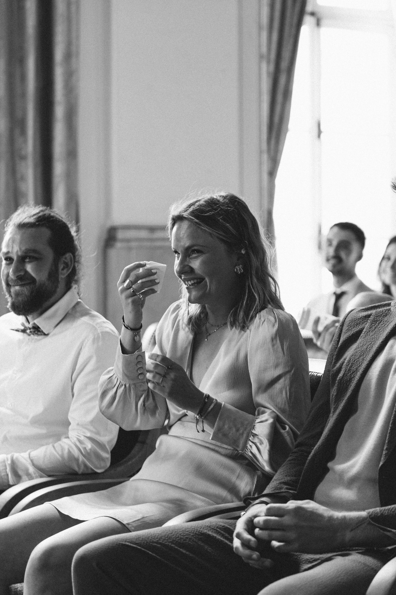 Black and white photographs of people laughing and socializing in a casual indoor setting.