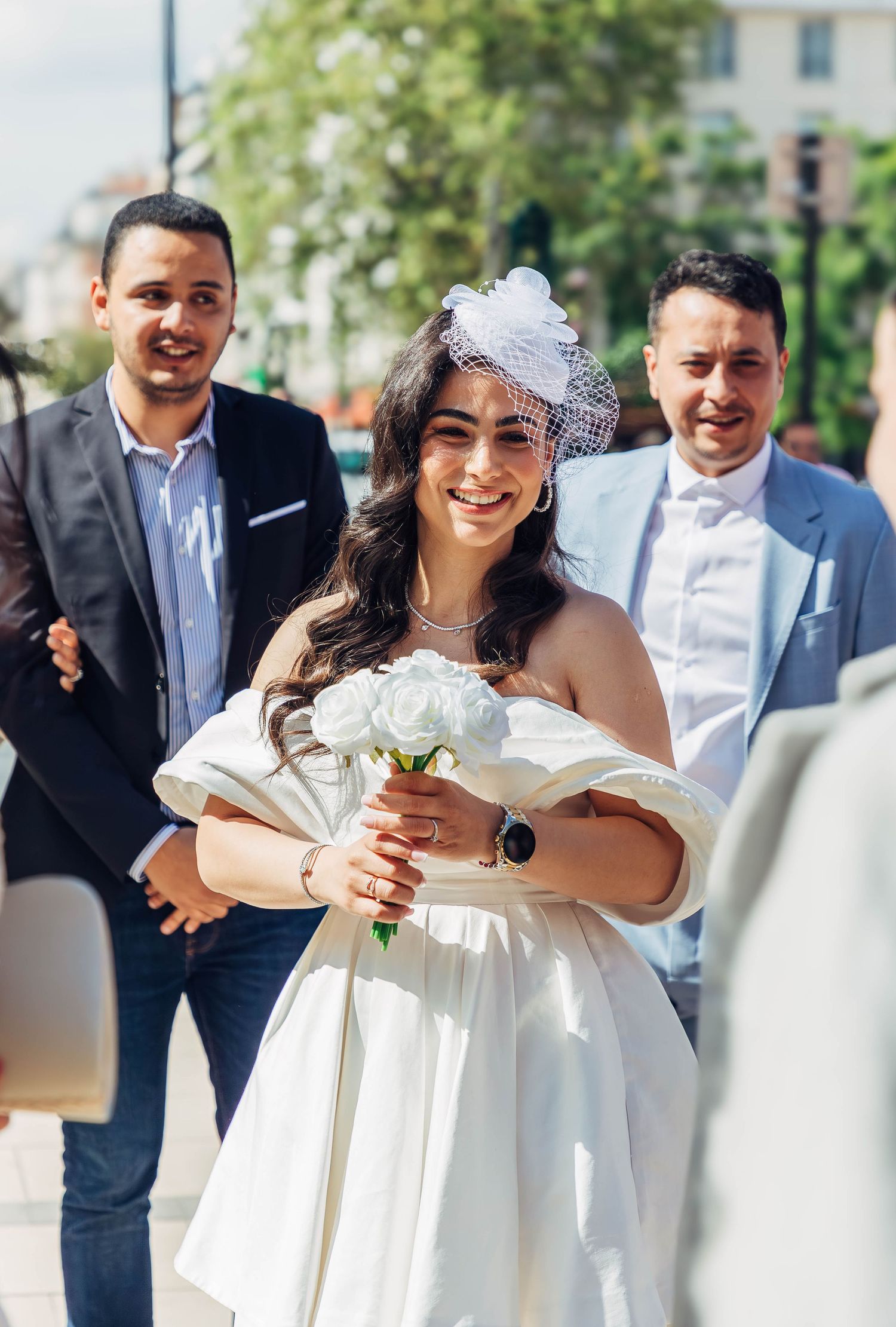 A wedding celebration on a sunny day with guests in formal attire.