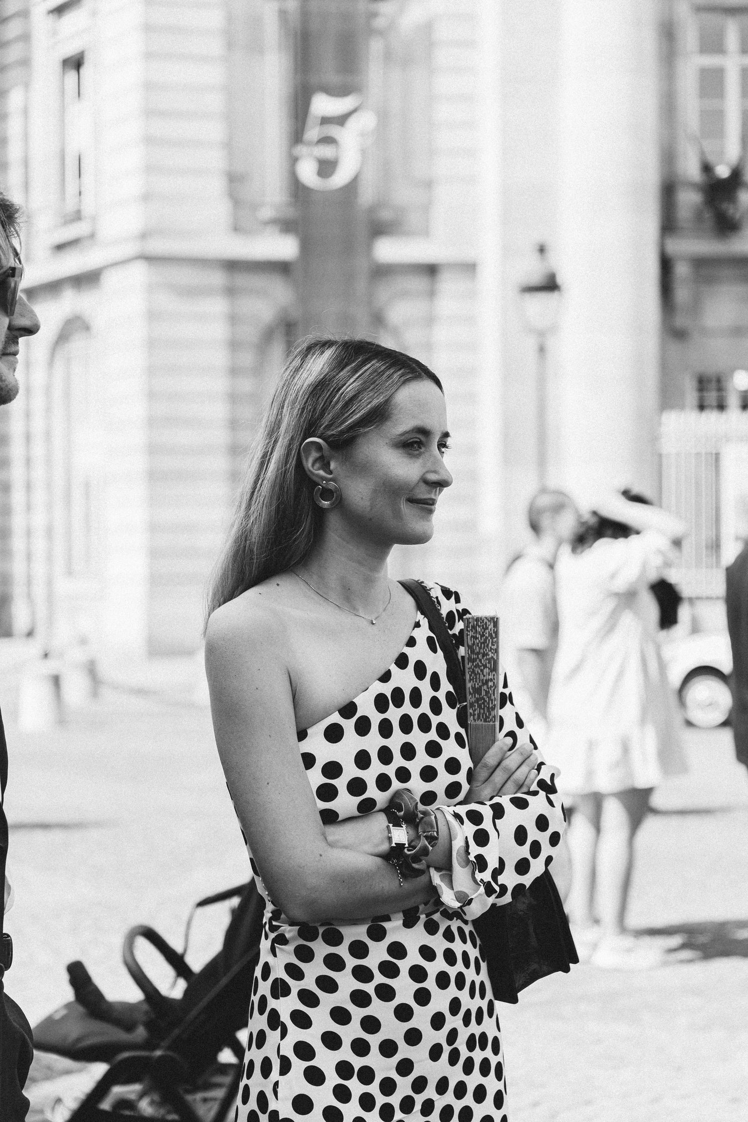 A series of black and white street photographs showing a person in a polka dot dress walking in an urban setting.