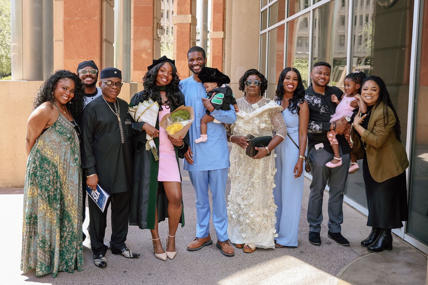 Large family group posing together outdoors at a formal celebration, dressed in elegant attire.